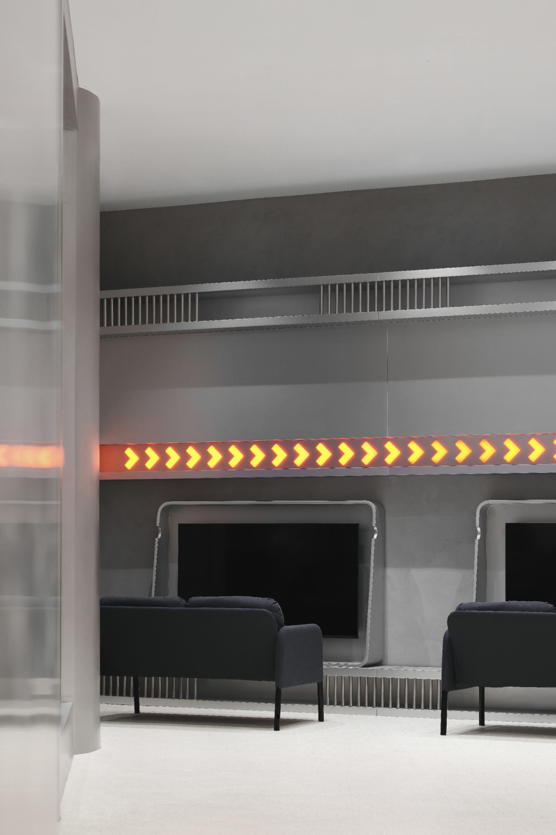 A minimalist office waiting area featuring metallic finishes, a sleek design, and a seating area.