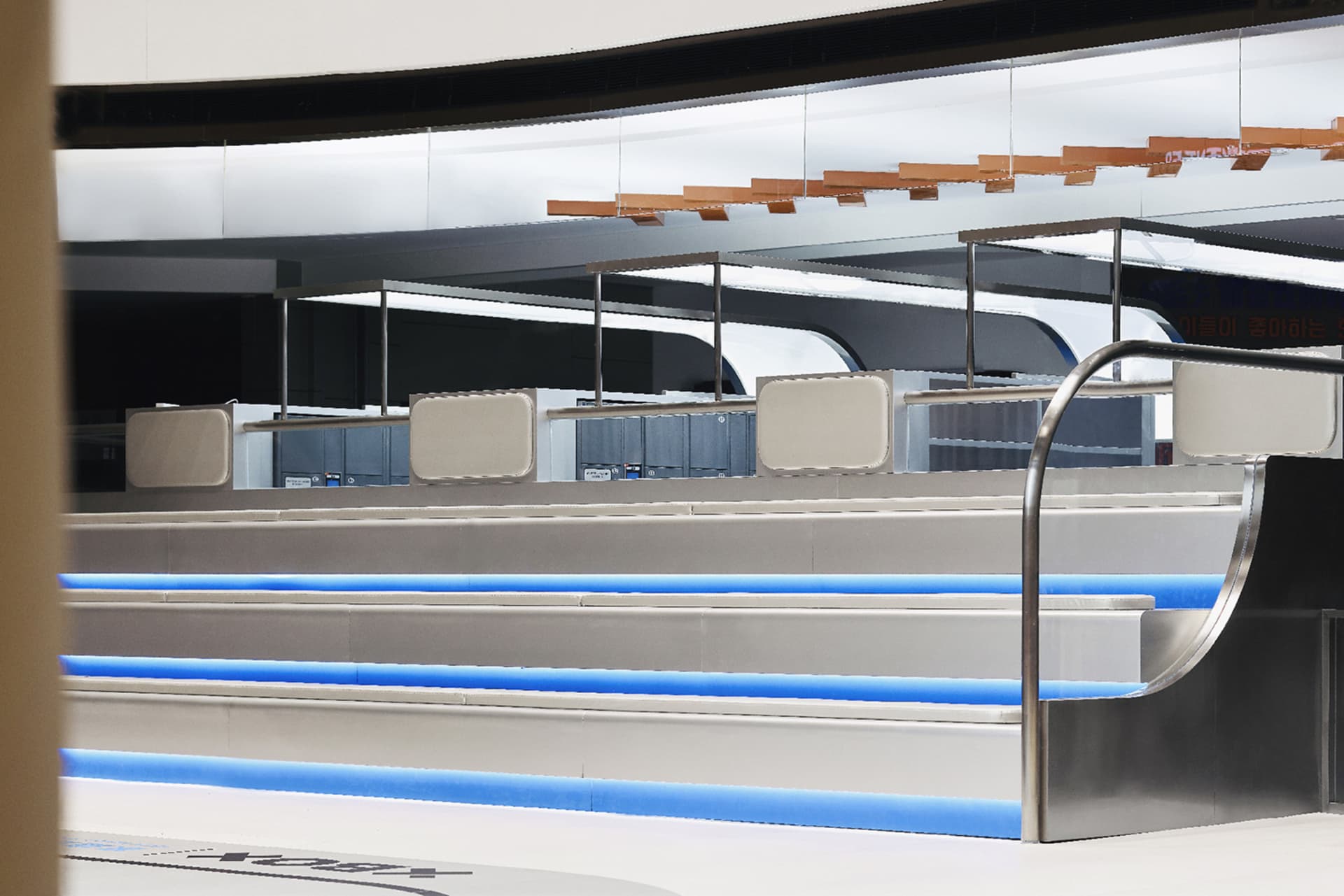 A sleek, metallic bar counter with blue lighting in a modern commercial interior.