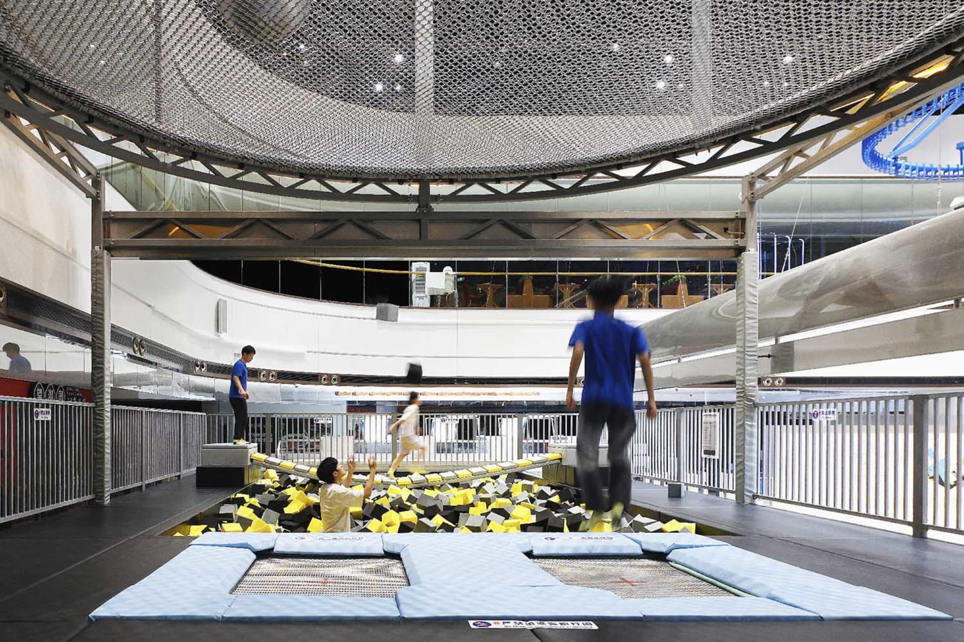 People playing in an indoor playground with foam cubes