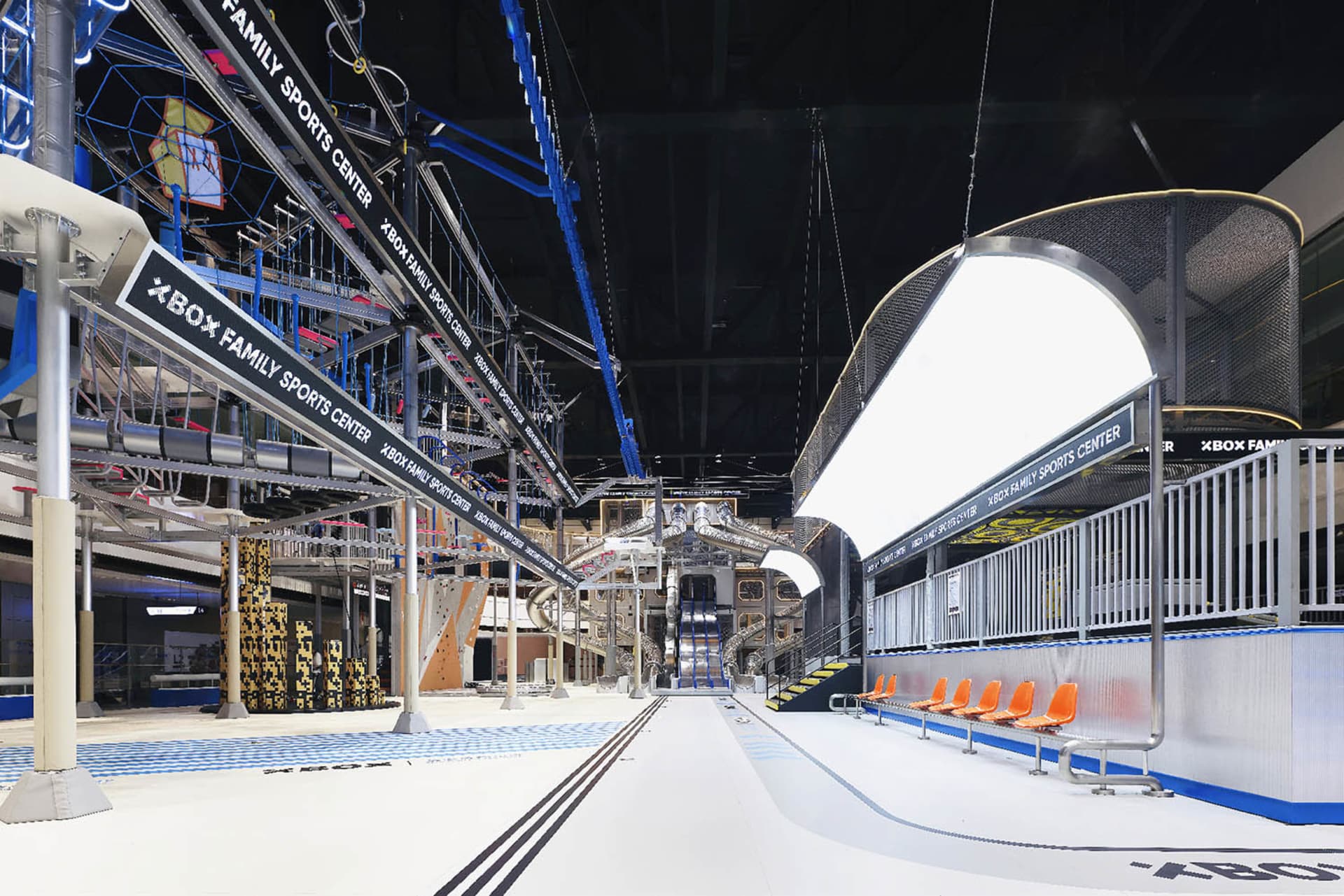 A modern sports center with metal beams, glass walls, and plastic tubing structures