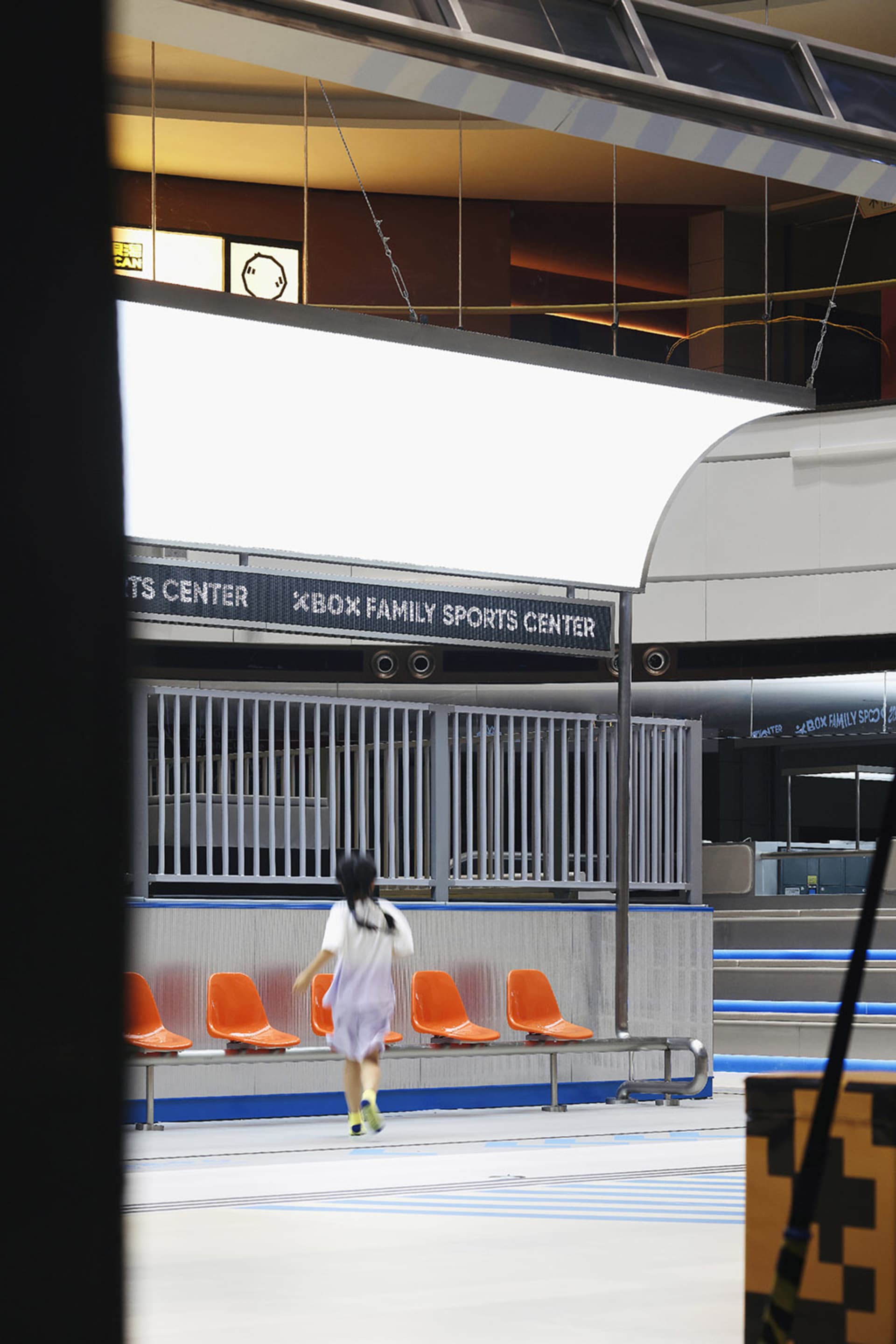 A modern sports center with metal railings and glass panels.