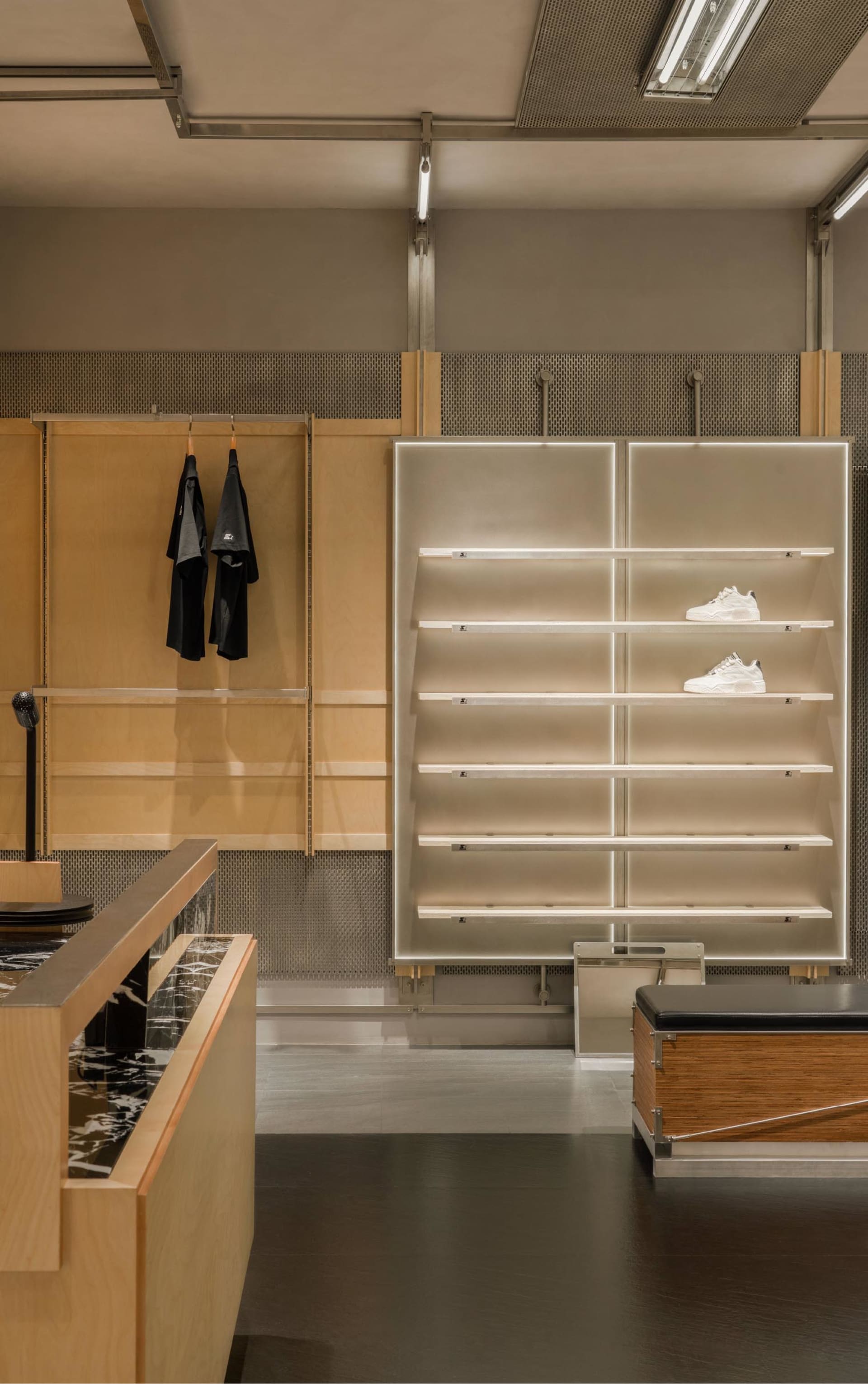 Modern retail shop with wooden shelves displaying white sneakers on the top shelves.