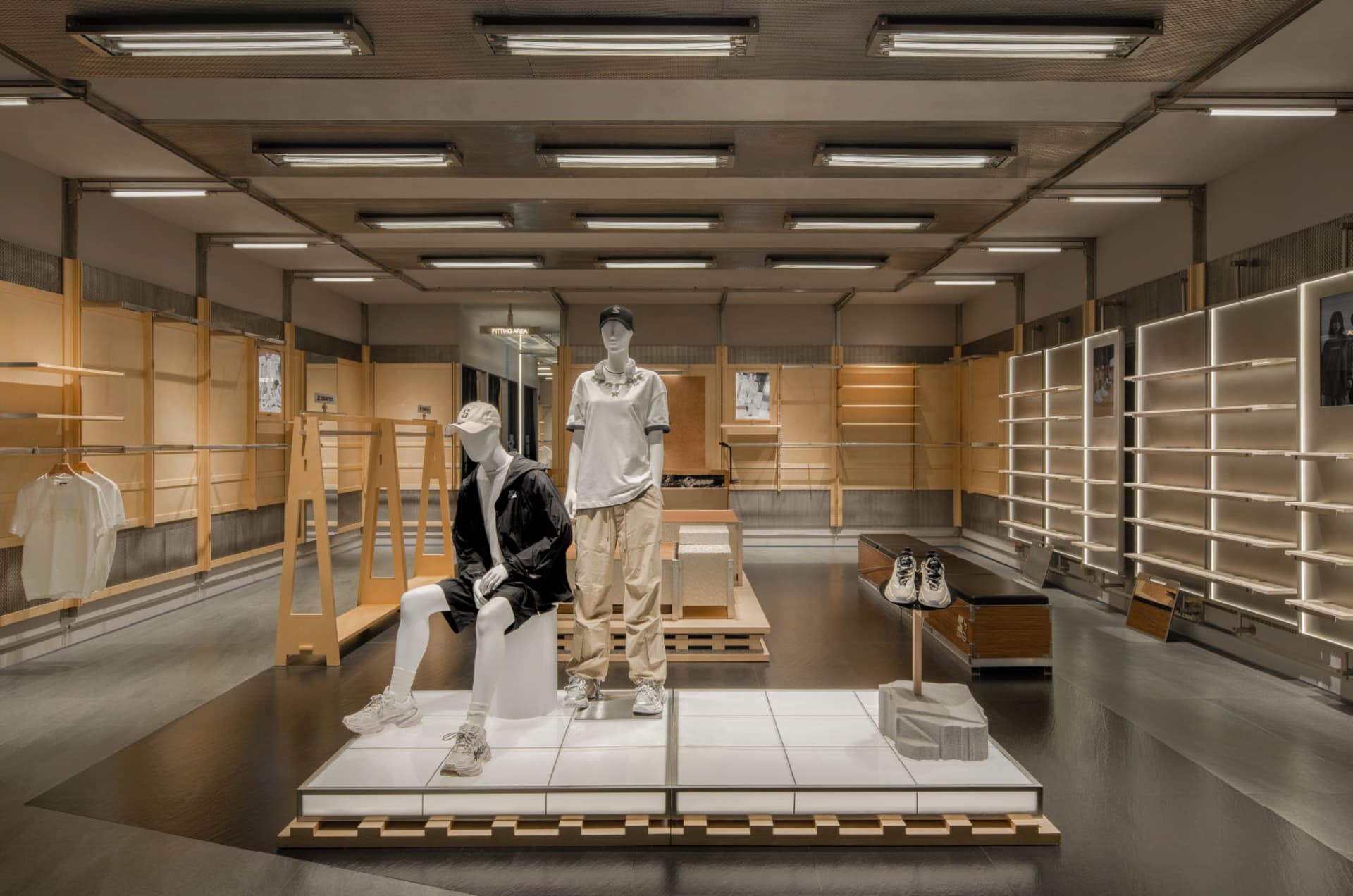 Modern retail store interior with minimalist design, featuring wood materials, and a focus on clothing racks and mannequins.