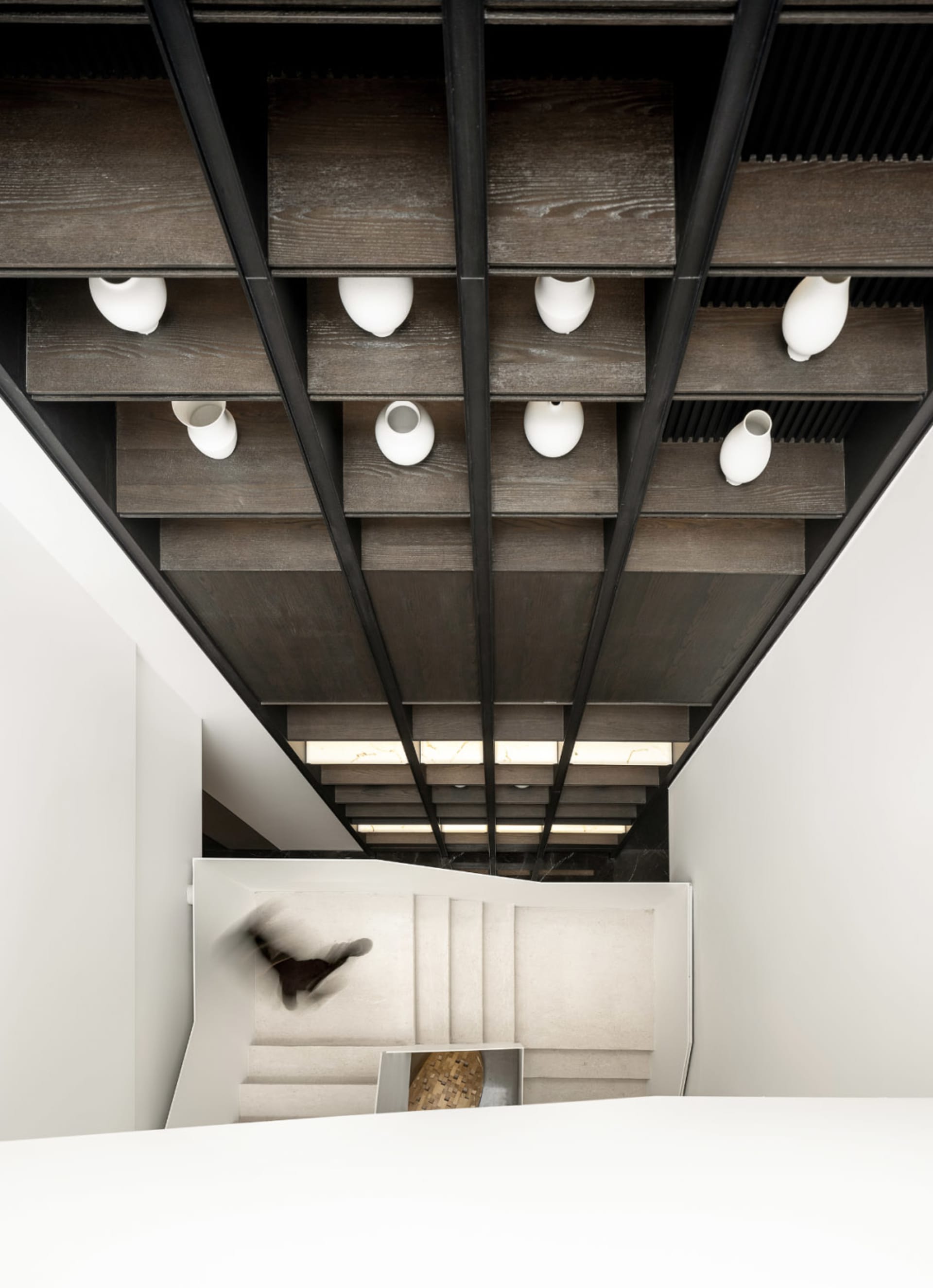 Modern minimalist staircase with wooden steps and metal railings.