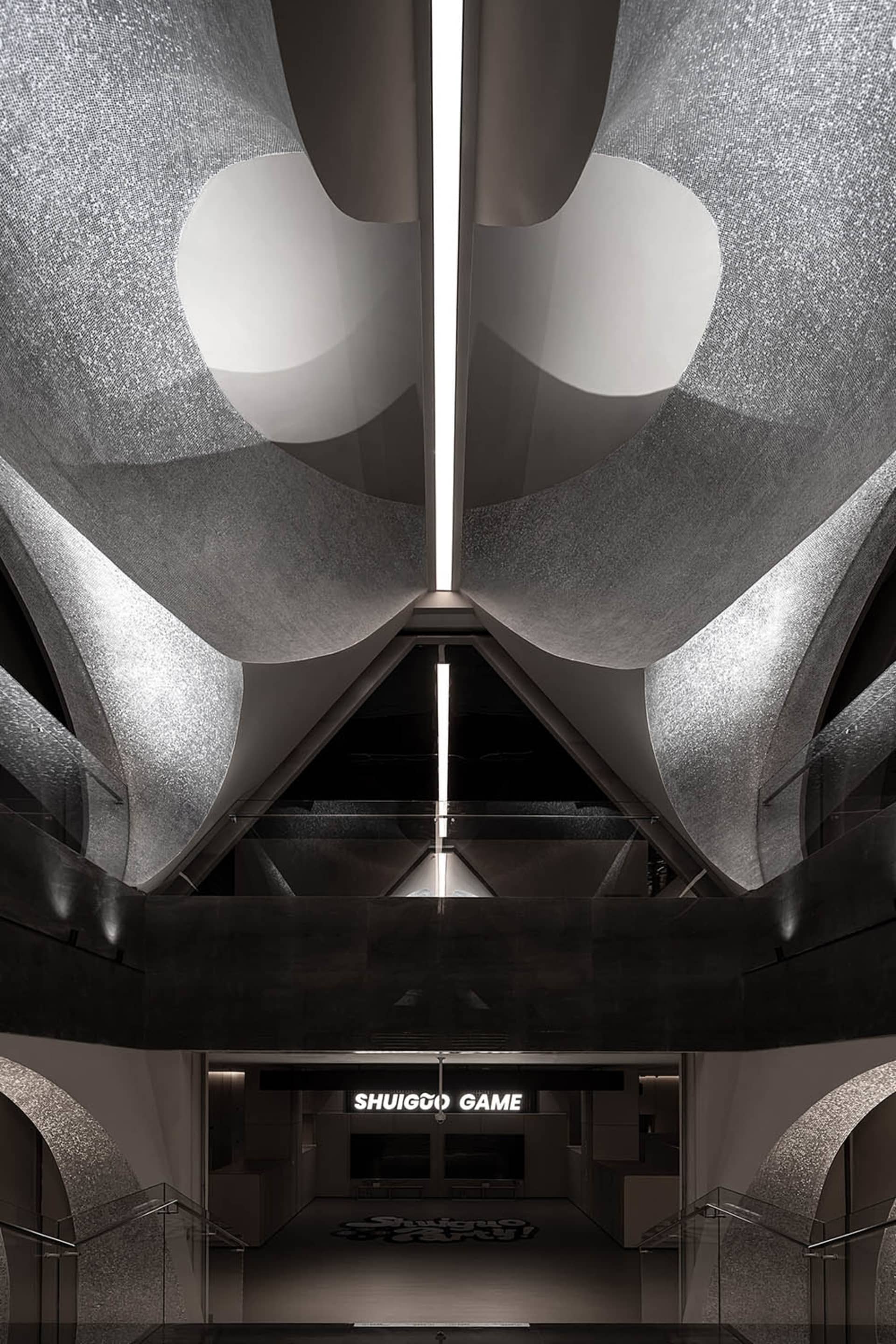 A modern restaurant with metallic finishes and geometric lighting fixtures.