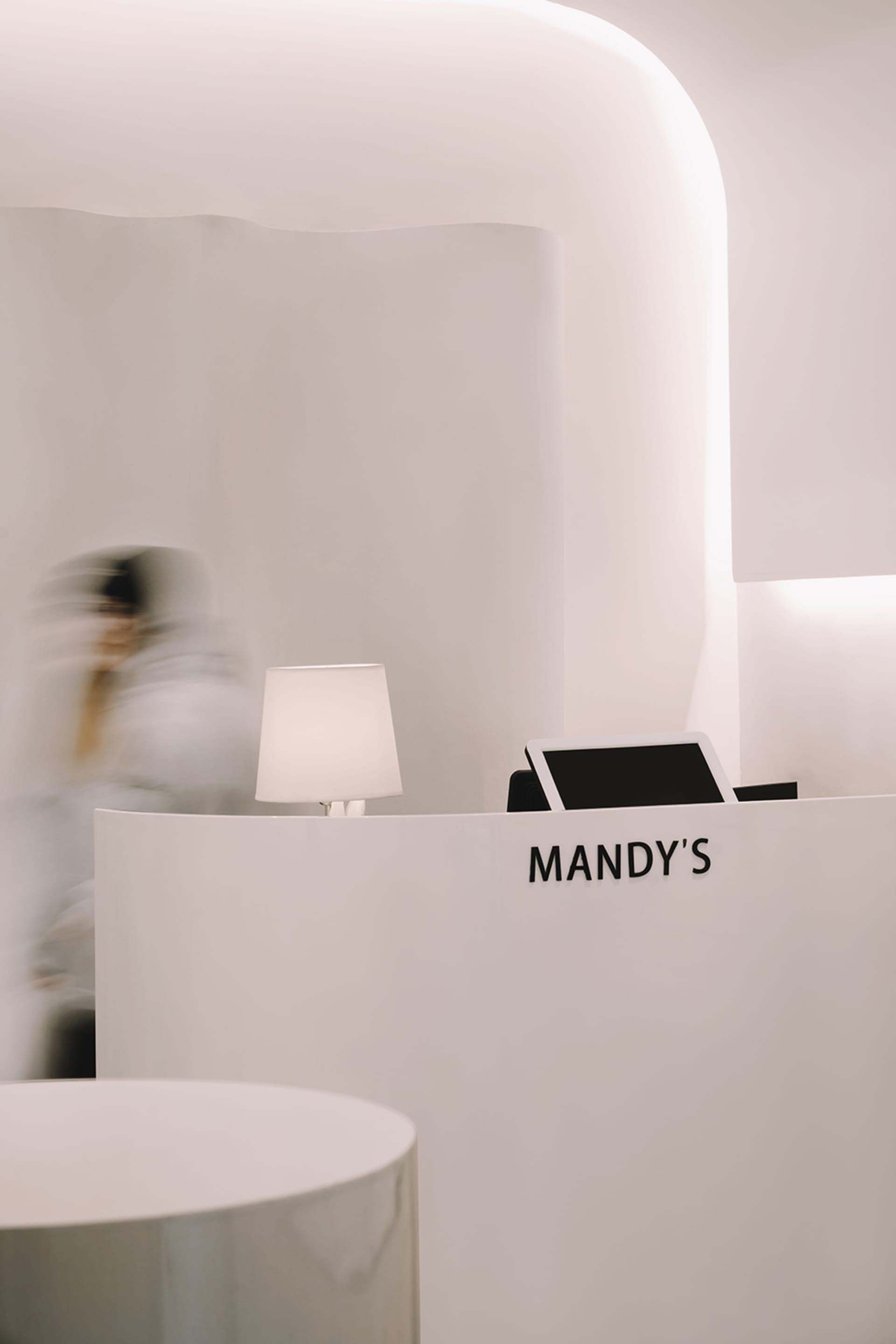 A minimalist spa reception desk made of white marble, featuring a sleek, modern design with clean lines and a simple, elegant