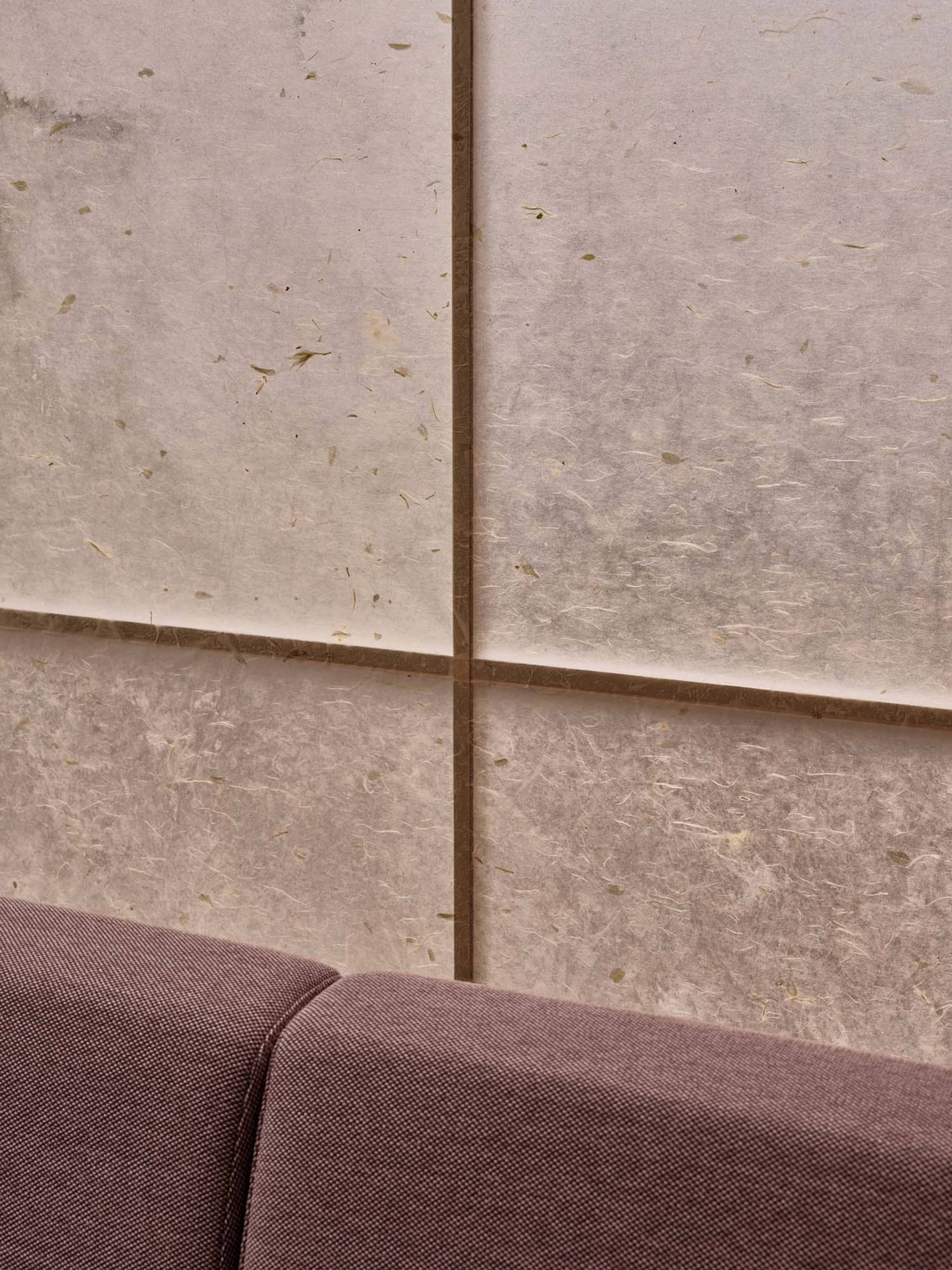 A close-up view of modern interior wall tiles made of paper, showcasing their textured surface and natural fibers.