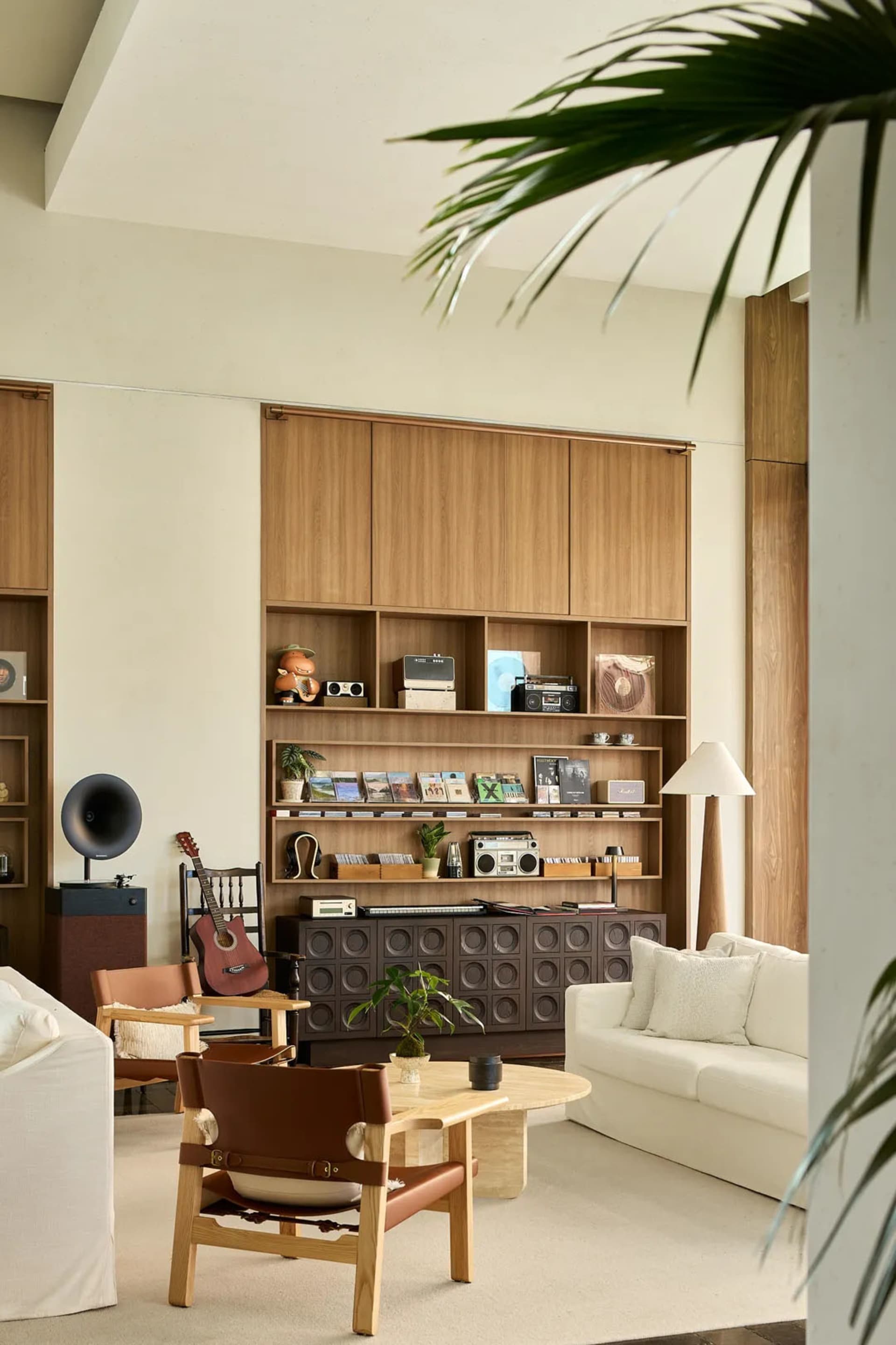 A modern minimalist living room featuring wood furniture and decor.