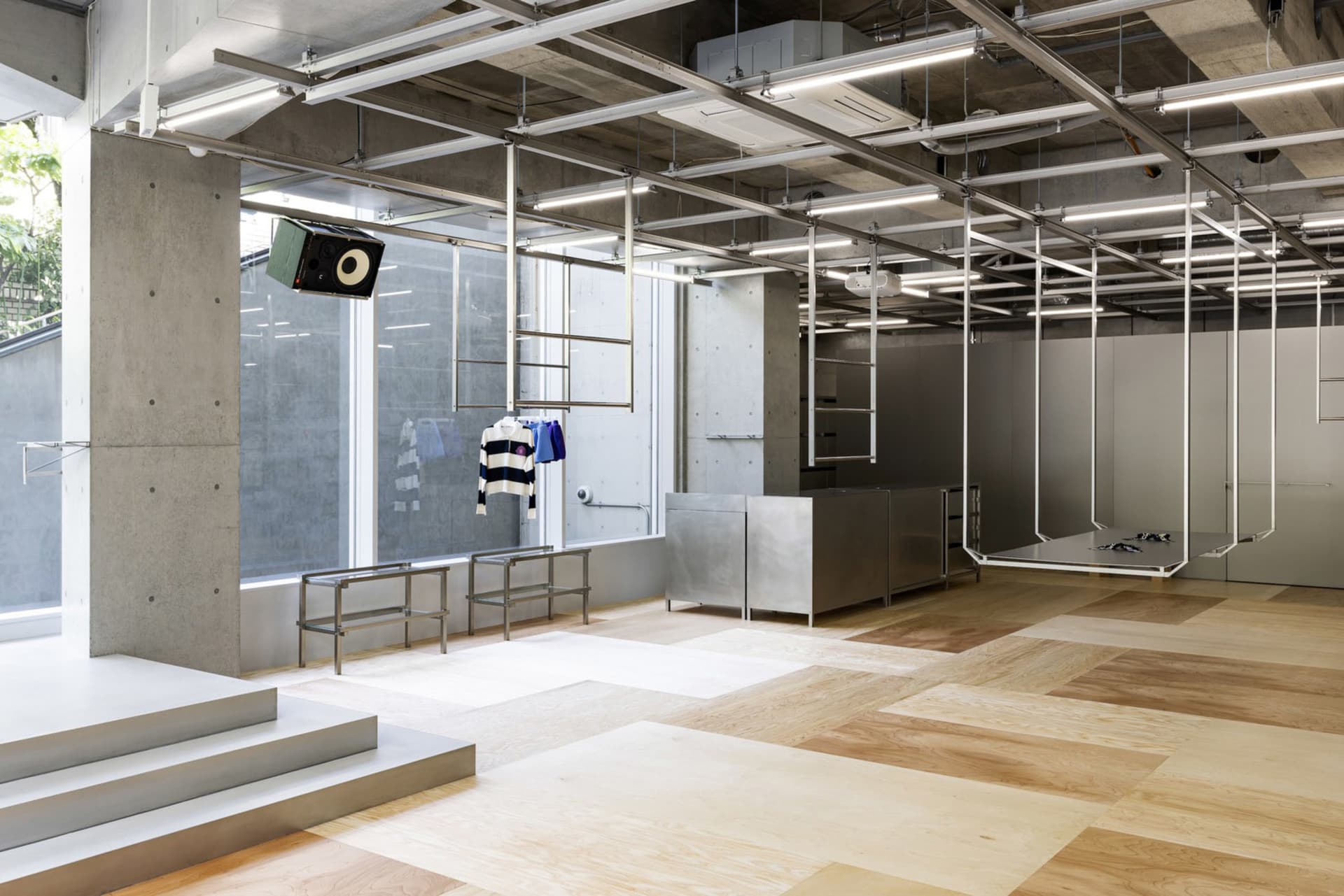 A modern industrial interior with a concrete floor, minimalist furniture, and exposed structural elements.