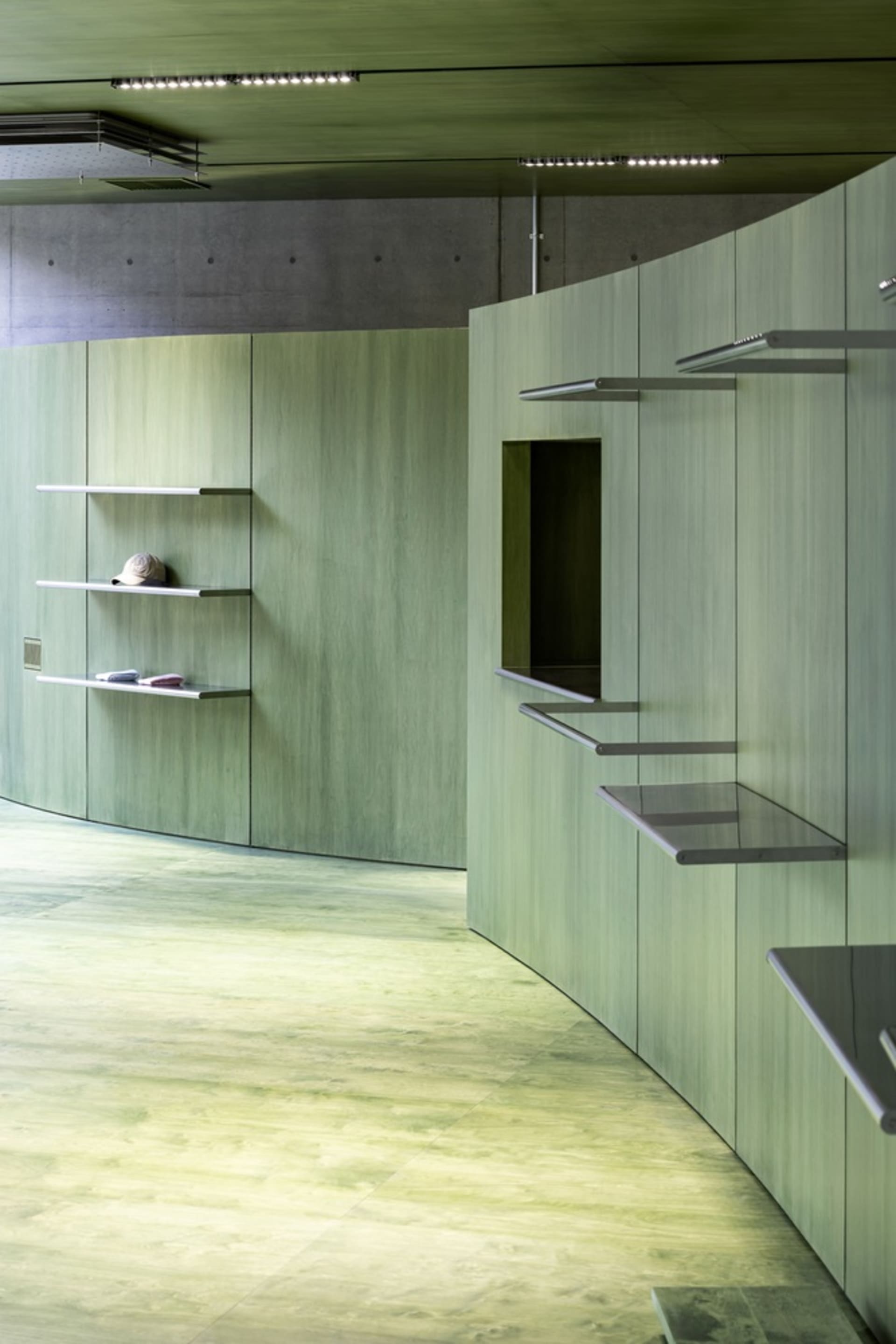 A modern interior space with concrete walls and shelves.