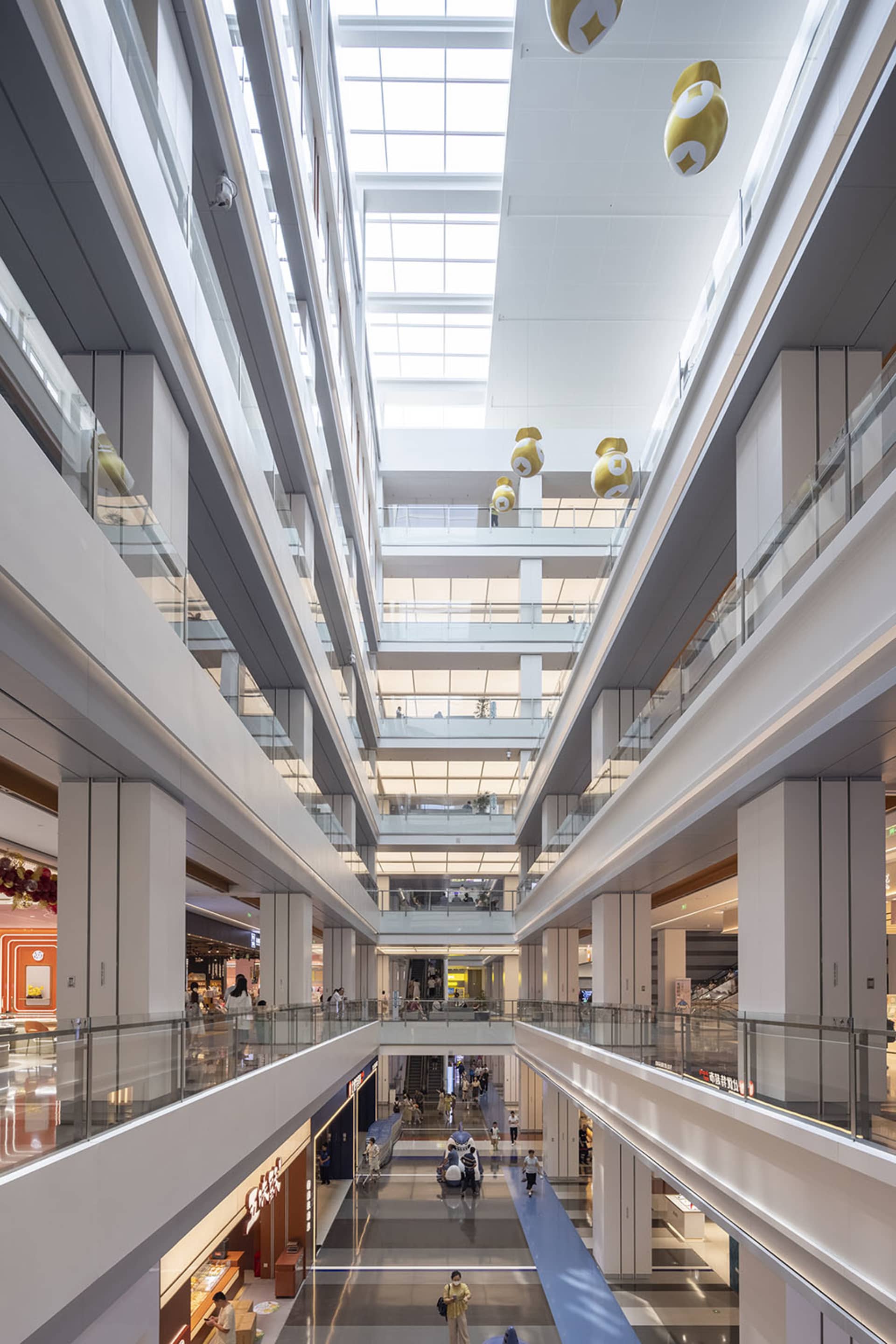 Modern shopping mall interior with glass, concrete and lighting features