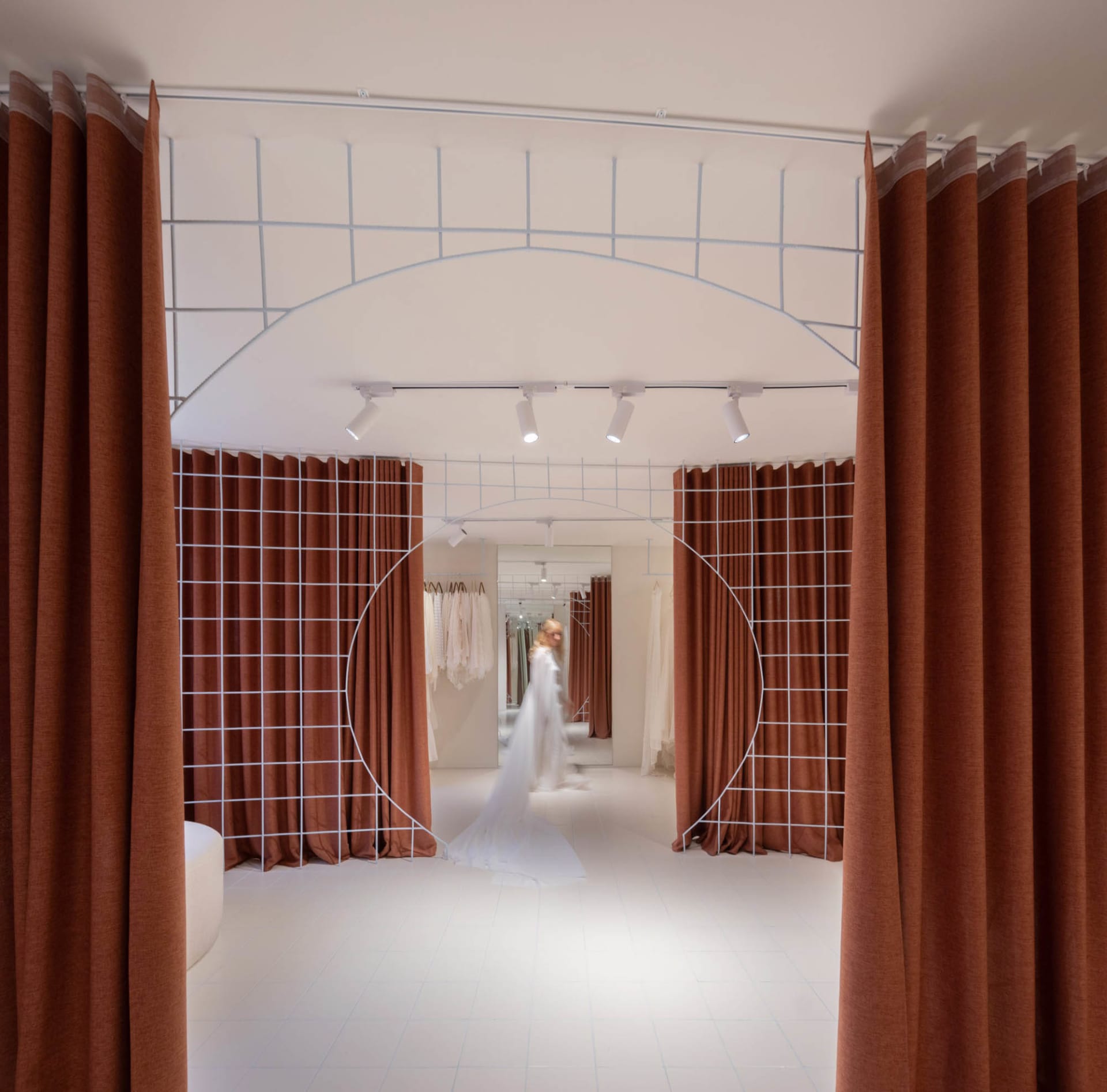 A modern retail interior featuring a transparent dress with fabric material and a metal grid structure.