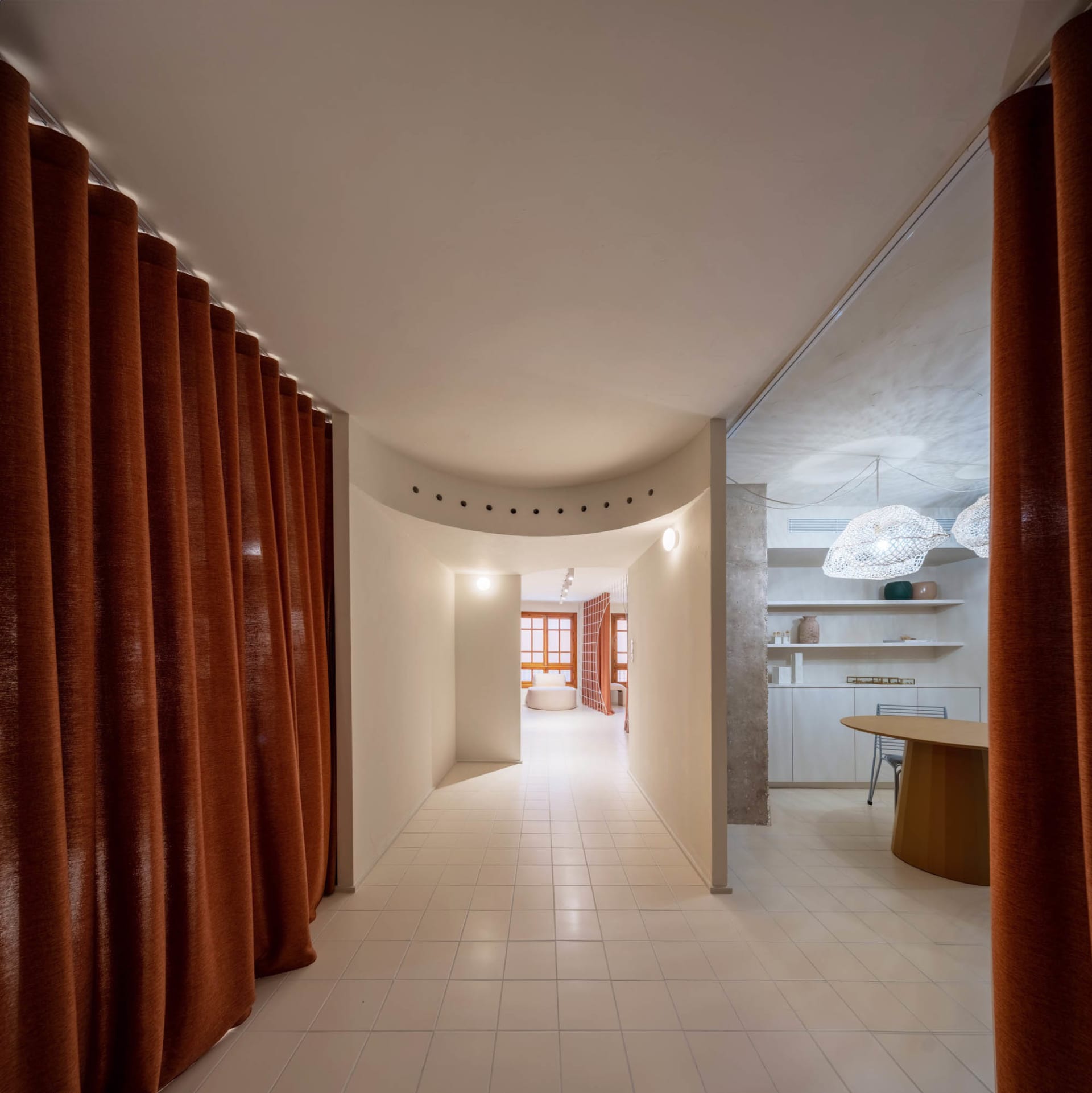 Neutral-colored hallway with concrete walls and white tile floor, modern design elements.