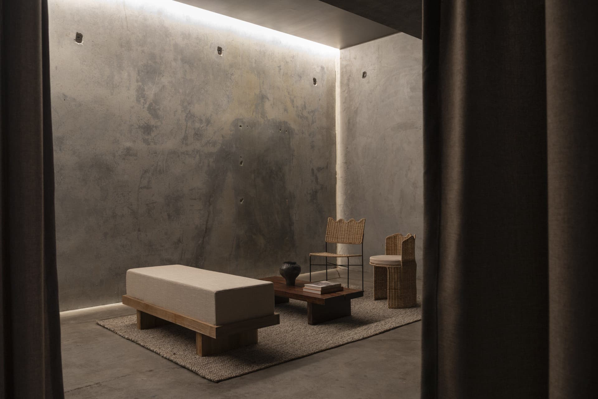 A modern living room with concrete walls and minimalist furniture
