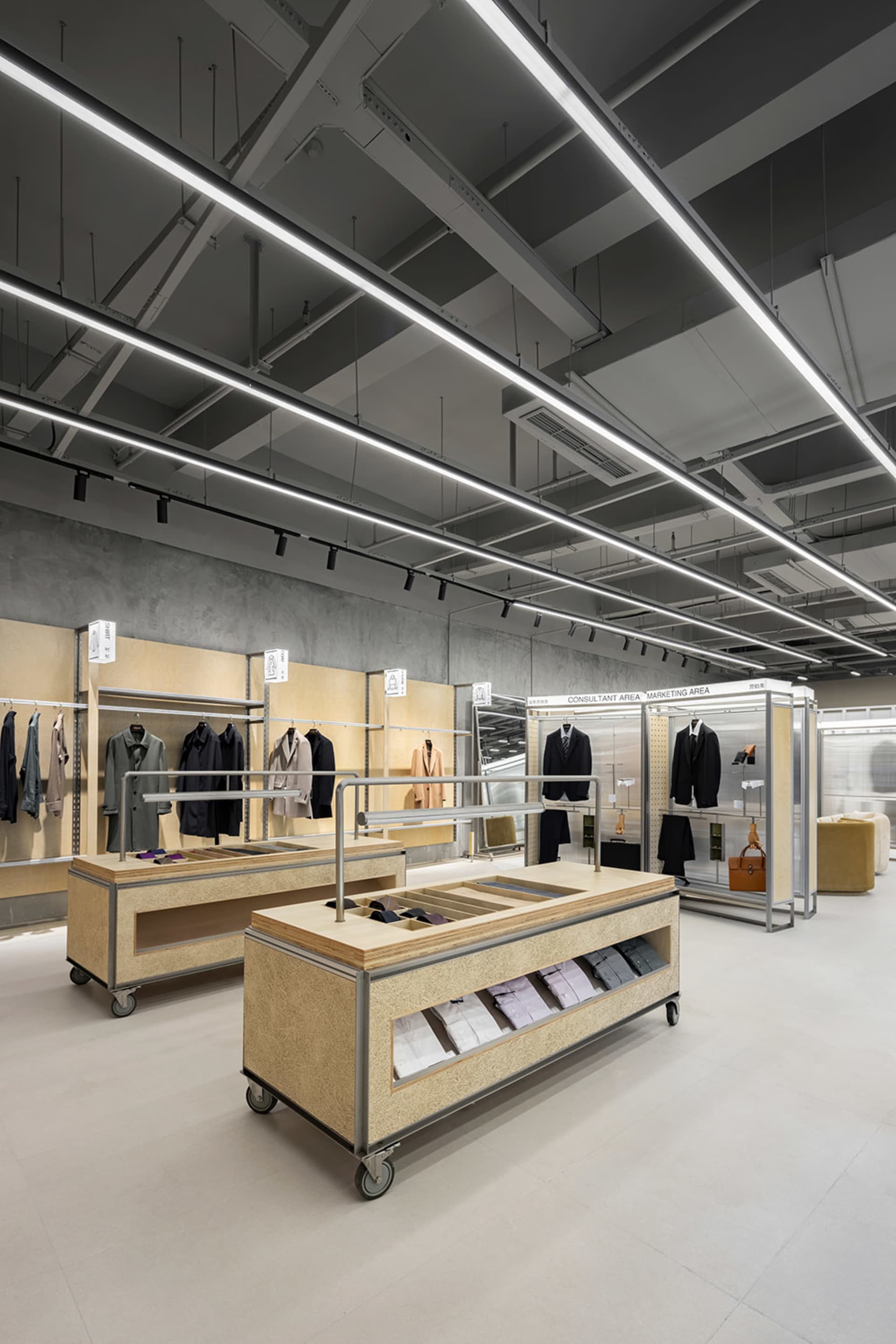 A clothing retail store with wooden surfaces, metal railings, and concrete walls.