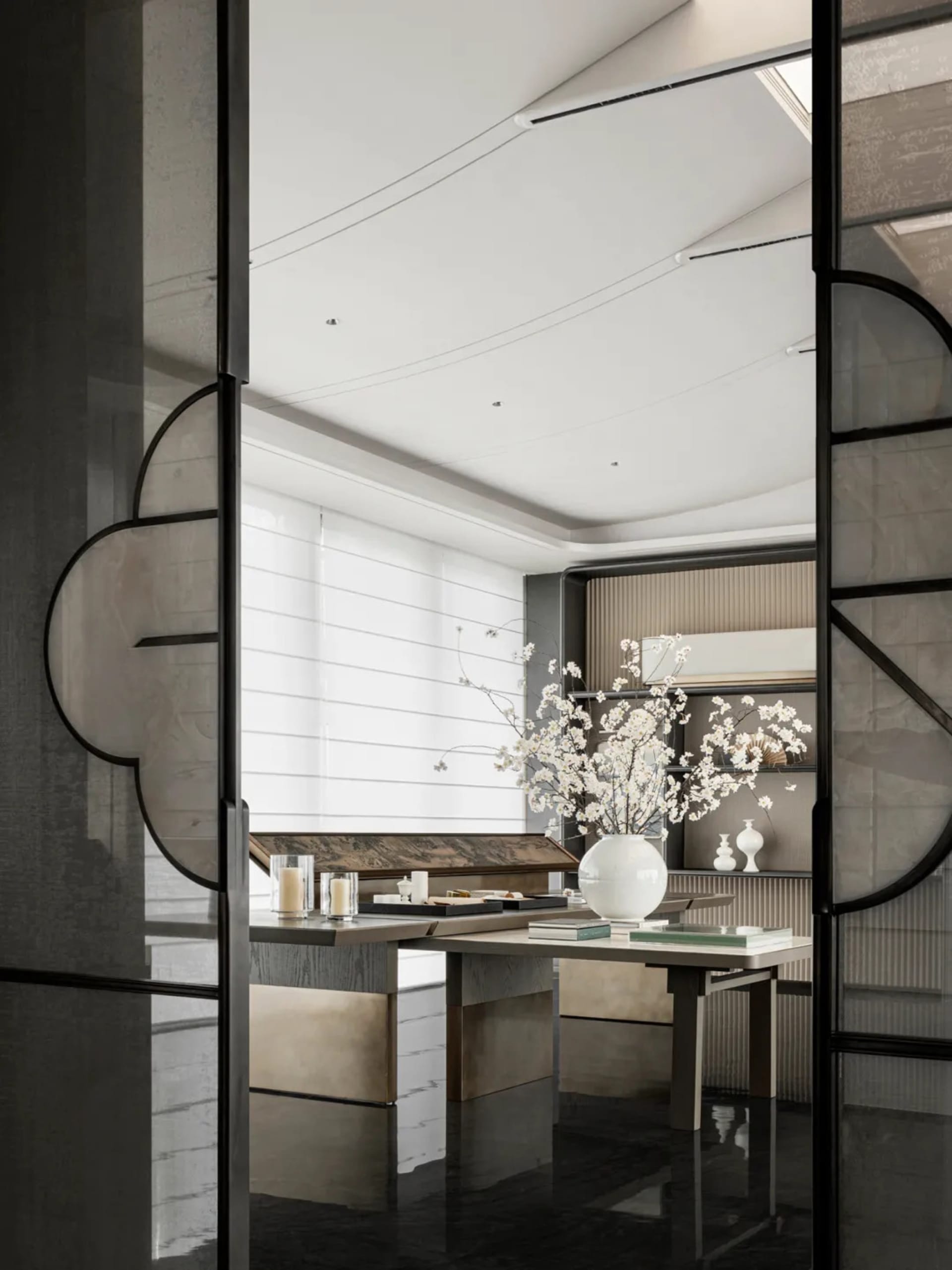 Modern minimalist living room featuring a white marble table with a white vase and book, black marble floor, and white wooden