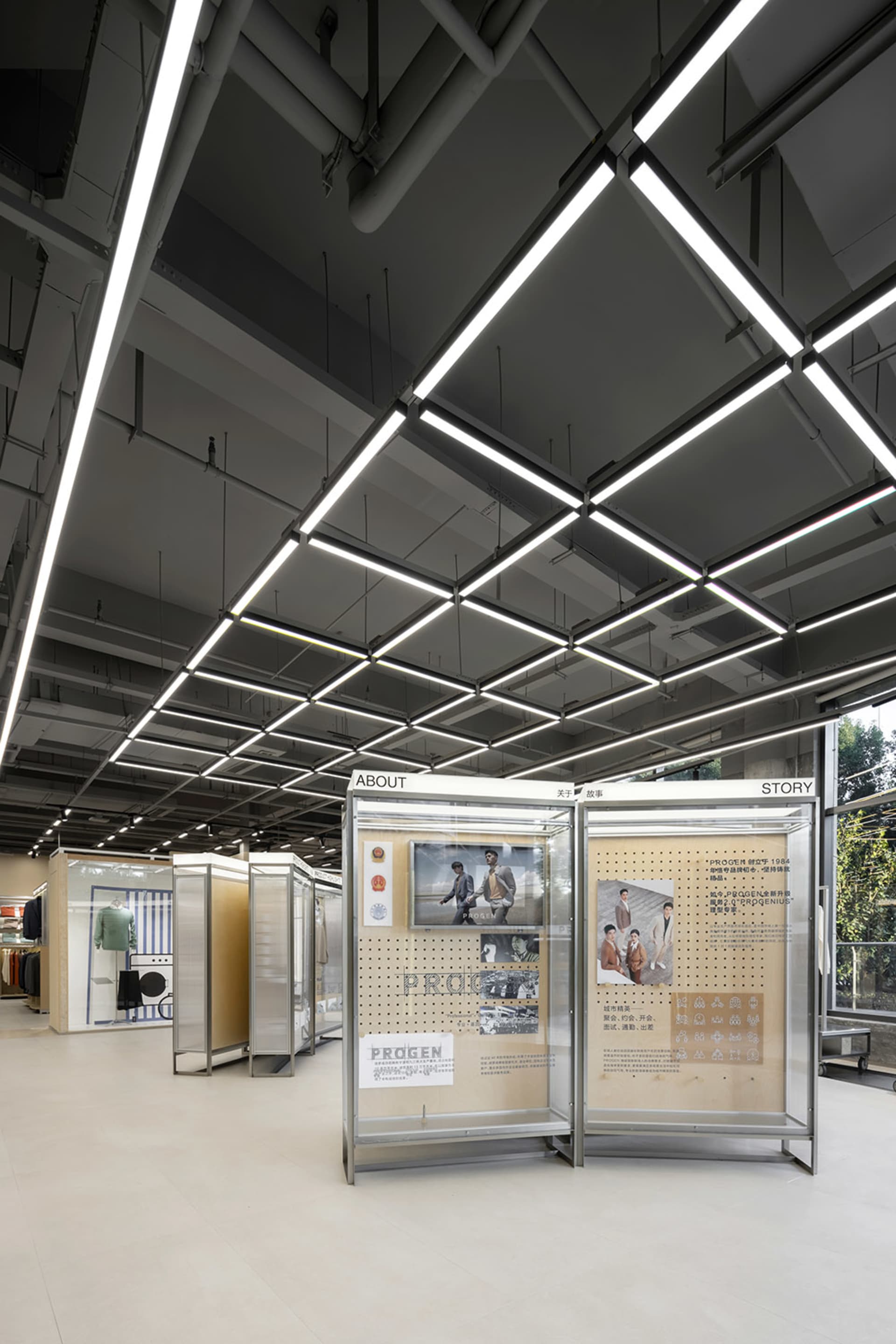 Modern retail space featuring glass and metal structural elements and lighting.