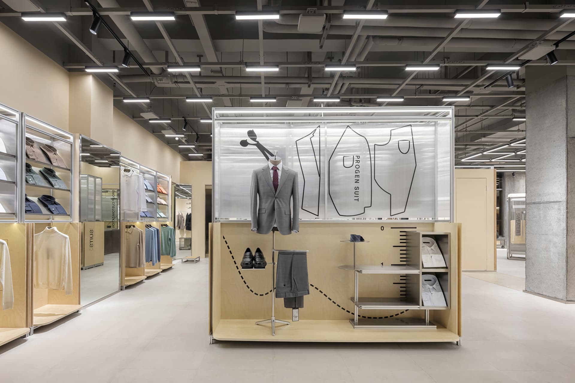 Retail interior with clothing shop showcasing wooden shelves, glass showcases, and metal fixtures.