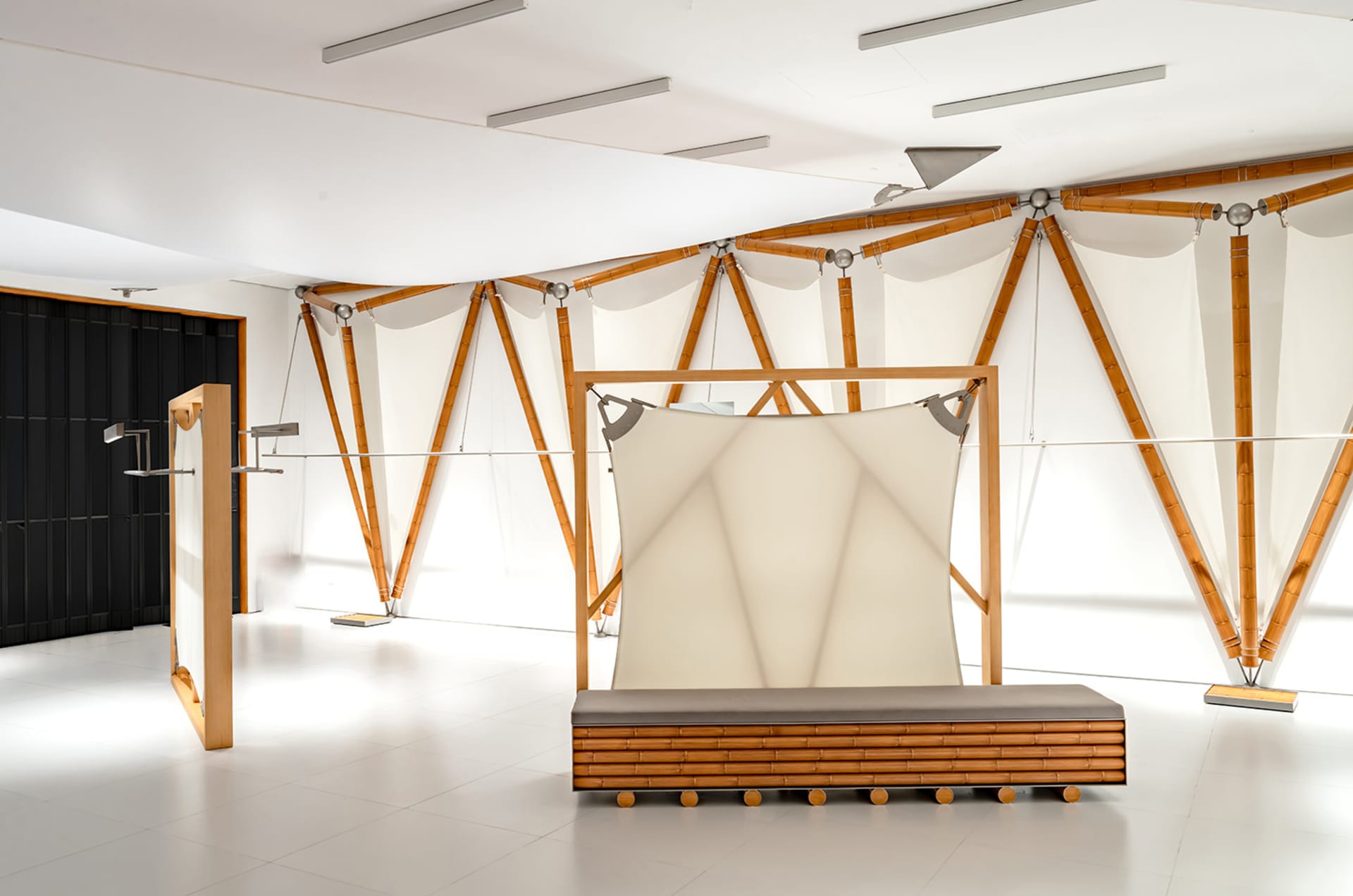 A minimalist interior design featuring wooden frames and light-colored textiles.