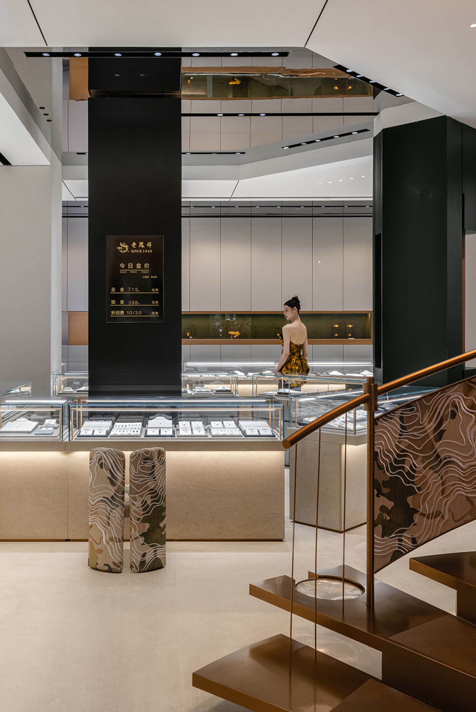 現代珠寶店室內，設有玻璃展示櫃、木製樓梯扶手與金屬柱。