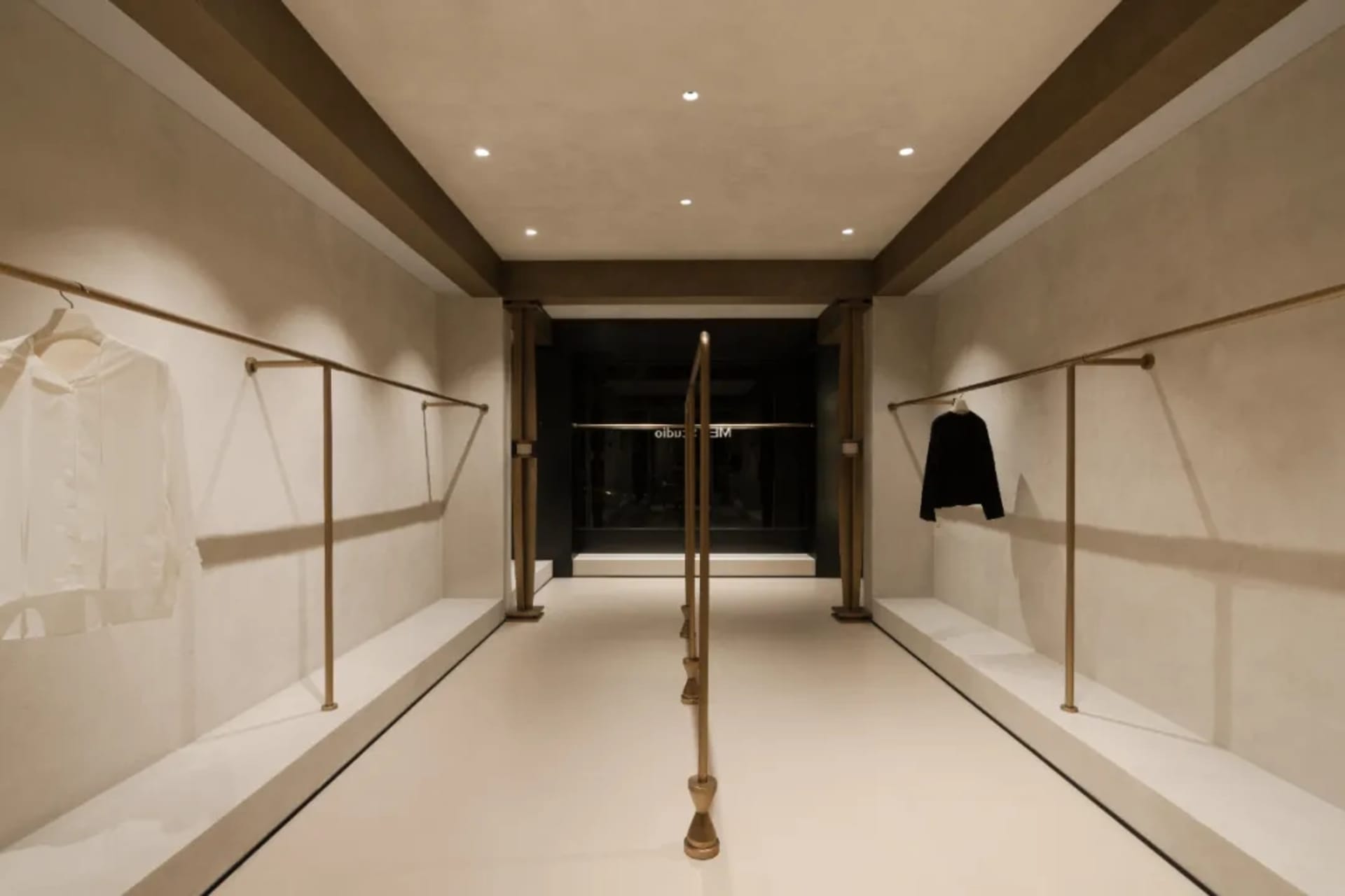 A sleek, modern storefront with a concrete exterior and metal accents, featuring a glass window and a clean, minimalist desig