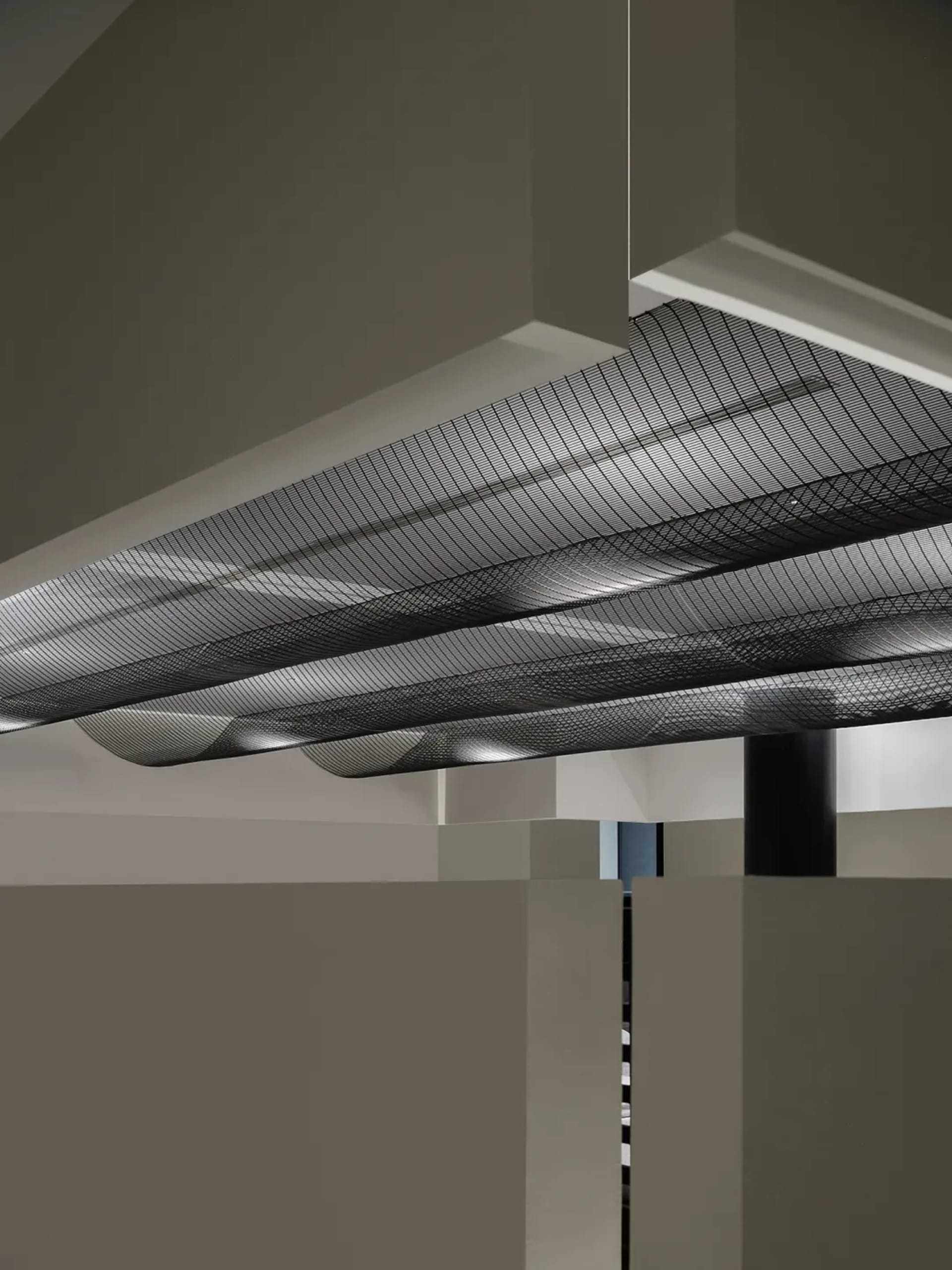 A modern interior design featuring a minimalist metal grid ceiling fixture.
