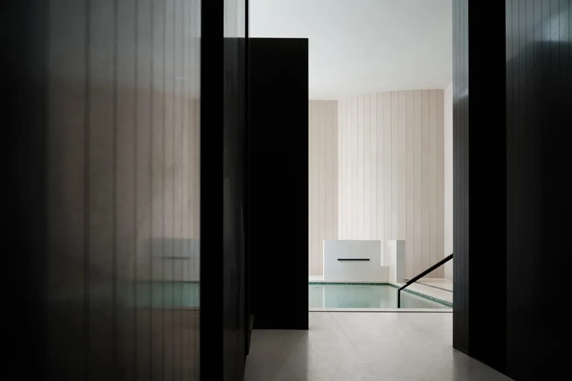 Modern minimalist swimming pool made of glass, viewed from a low angle.