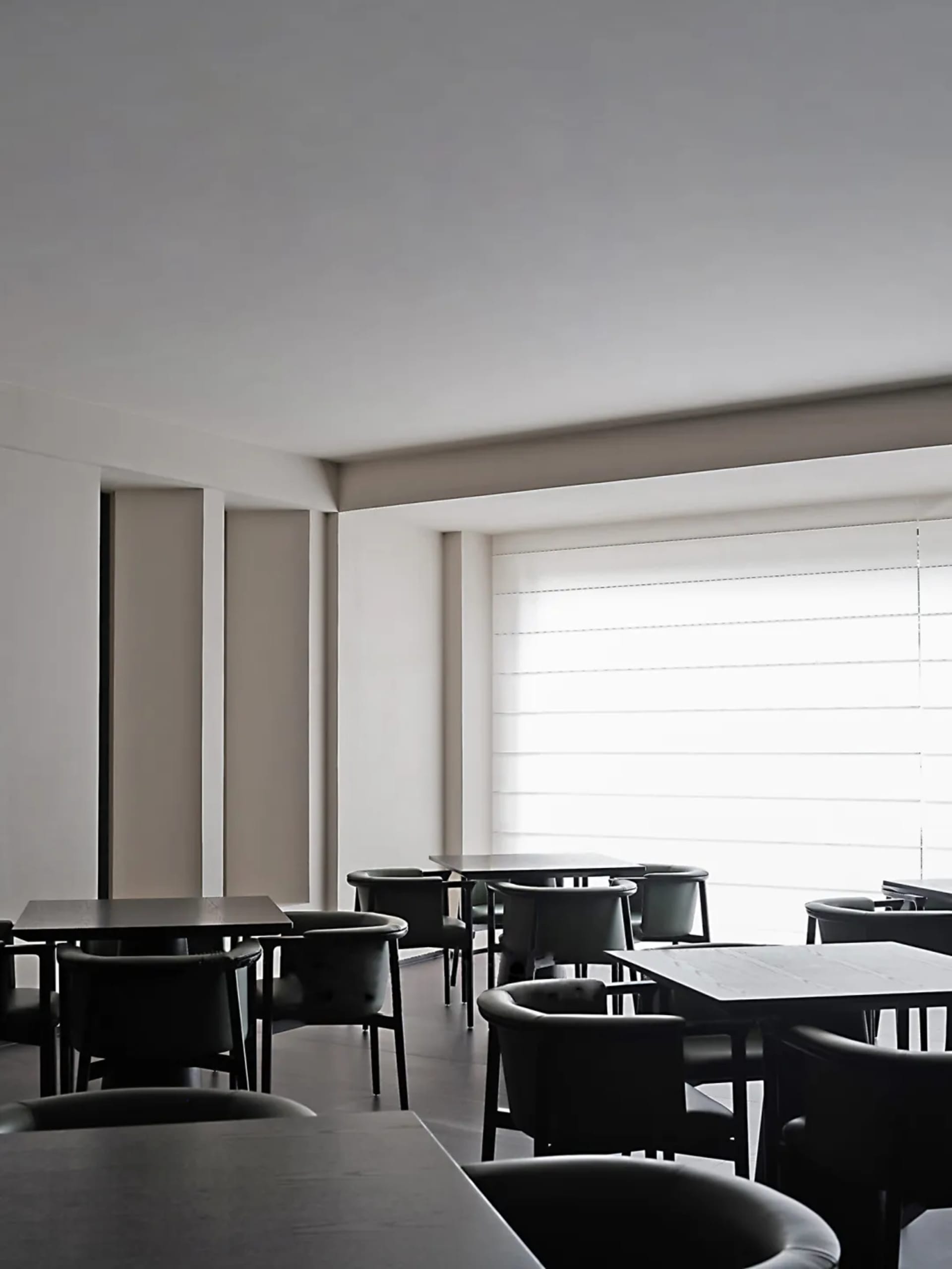 A modern restaurant interior featuring glass tables and minimalist design.