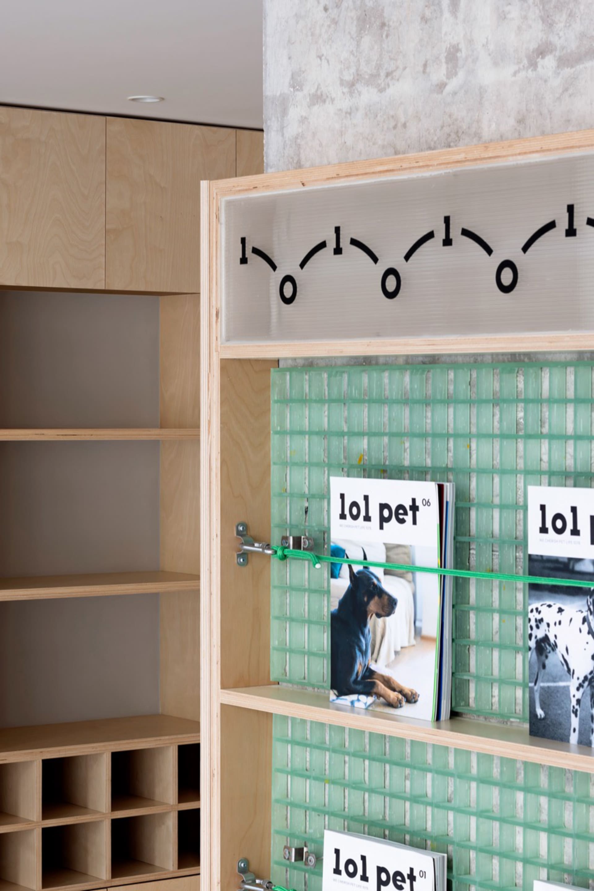 A glass magazine display shelf featuring a clock and magazines.