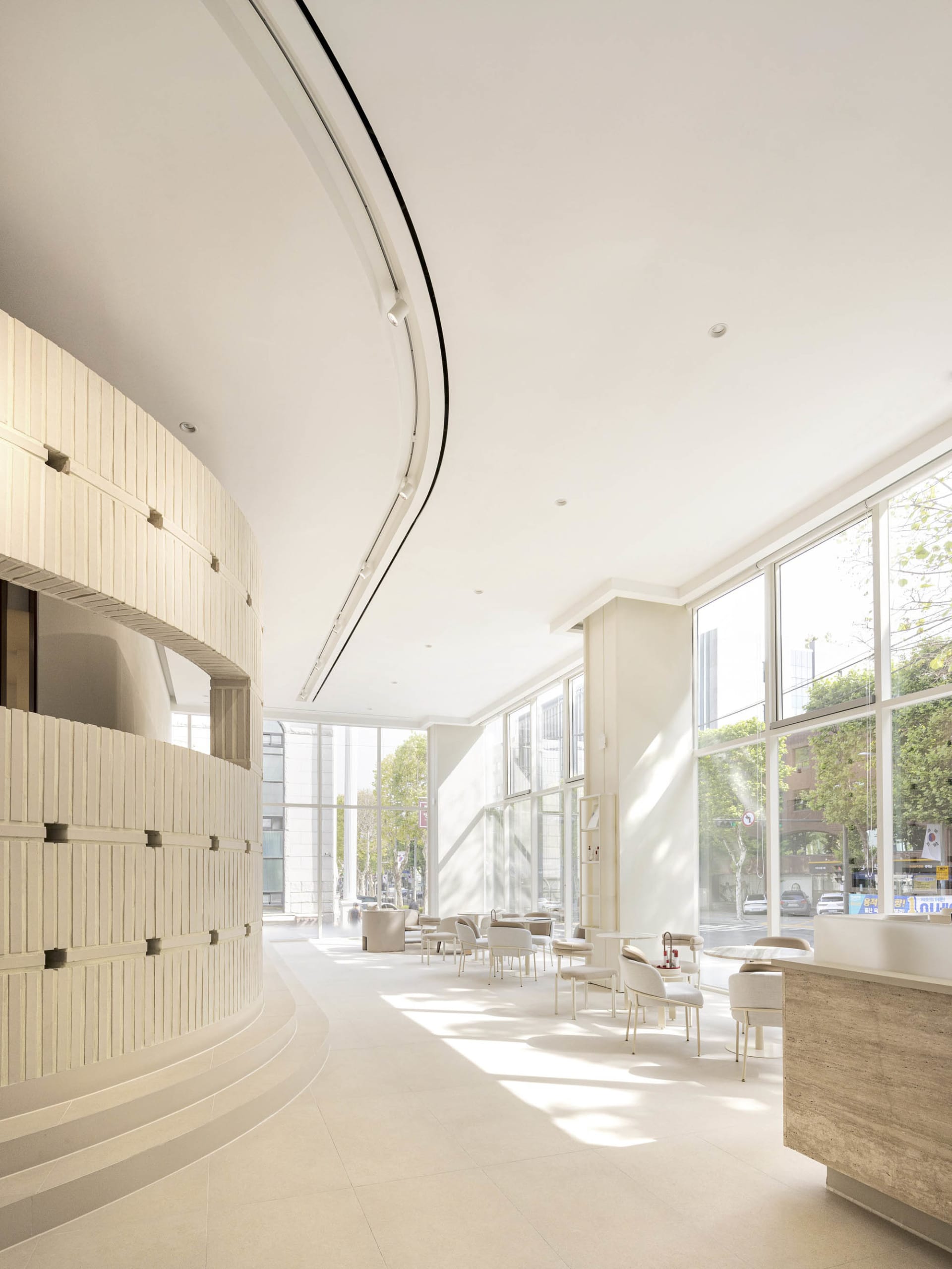 Modern, minimalist commercial interior with large windows showcasing a sleek, contemporary design.
