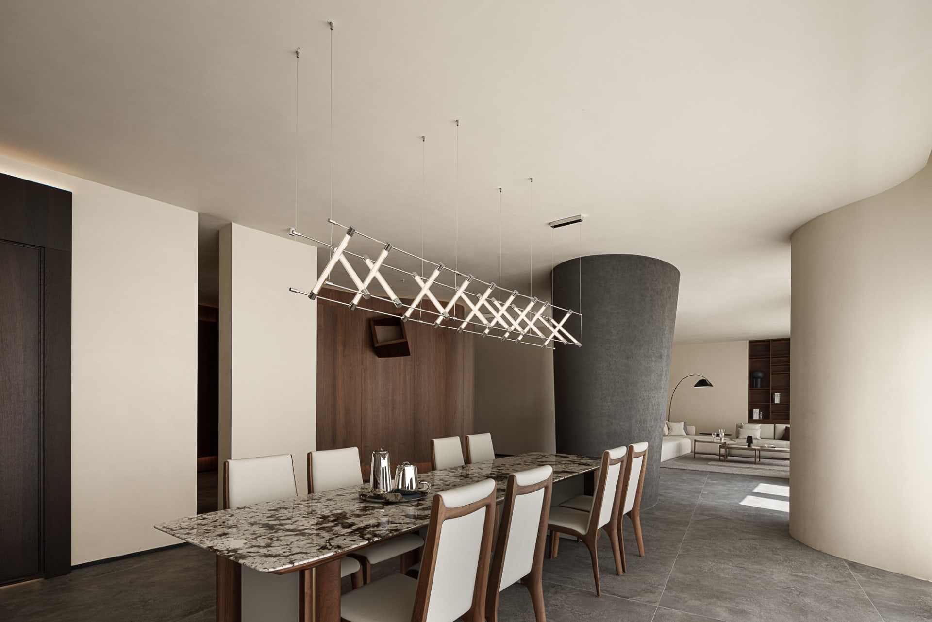 Modern interior design featuring a marble dining table and chairs, with a contemporary living area in the background.