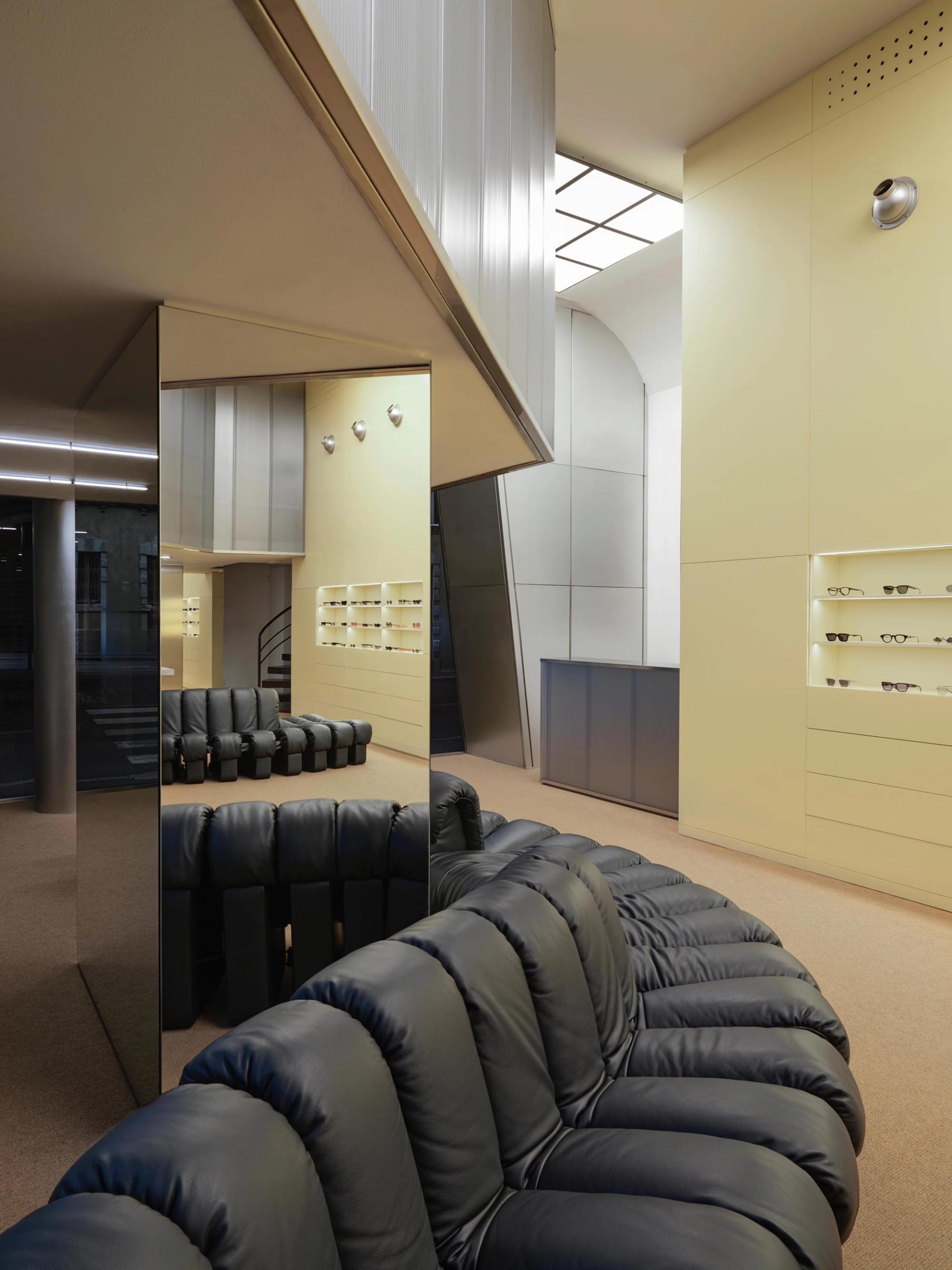 Modern retail space featuring black leather seating and display shelves showcasing various products.