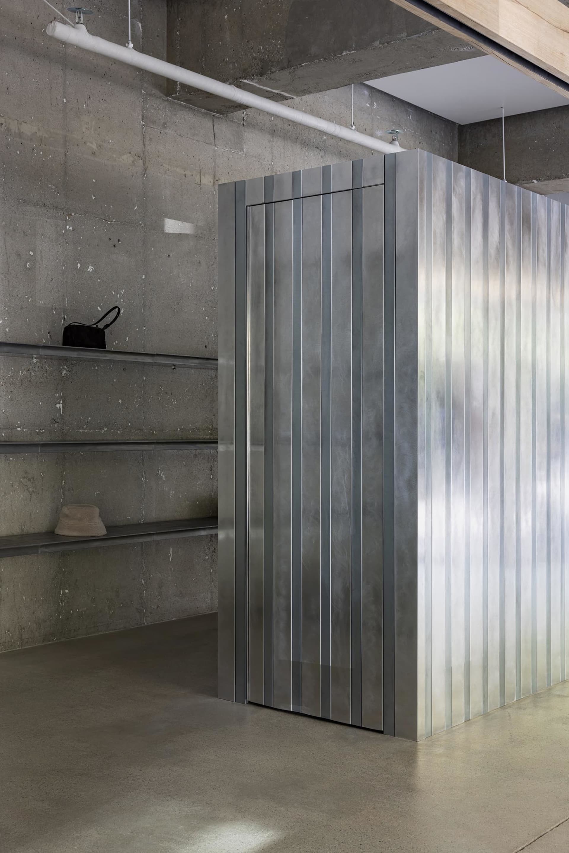 A modern industrial space featuring metallic panels on the wall.