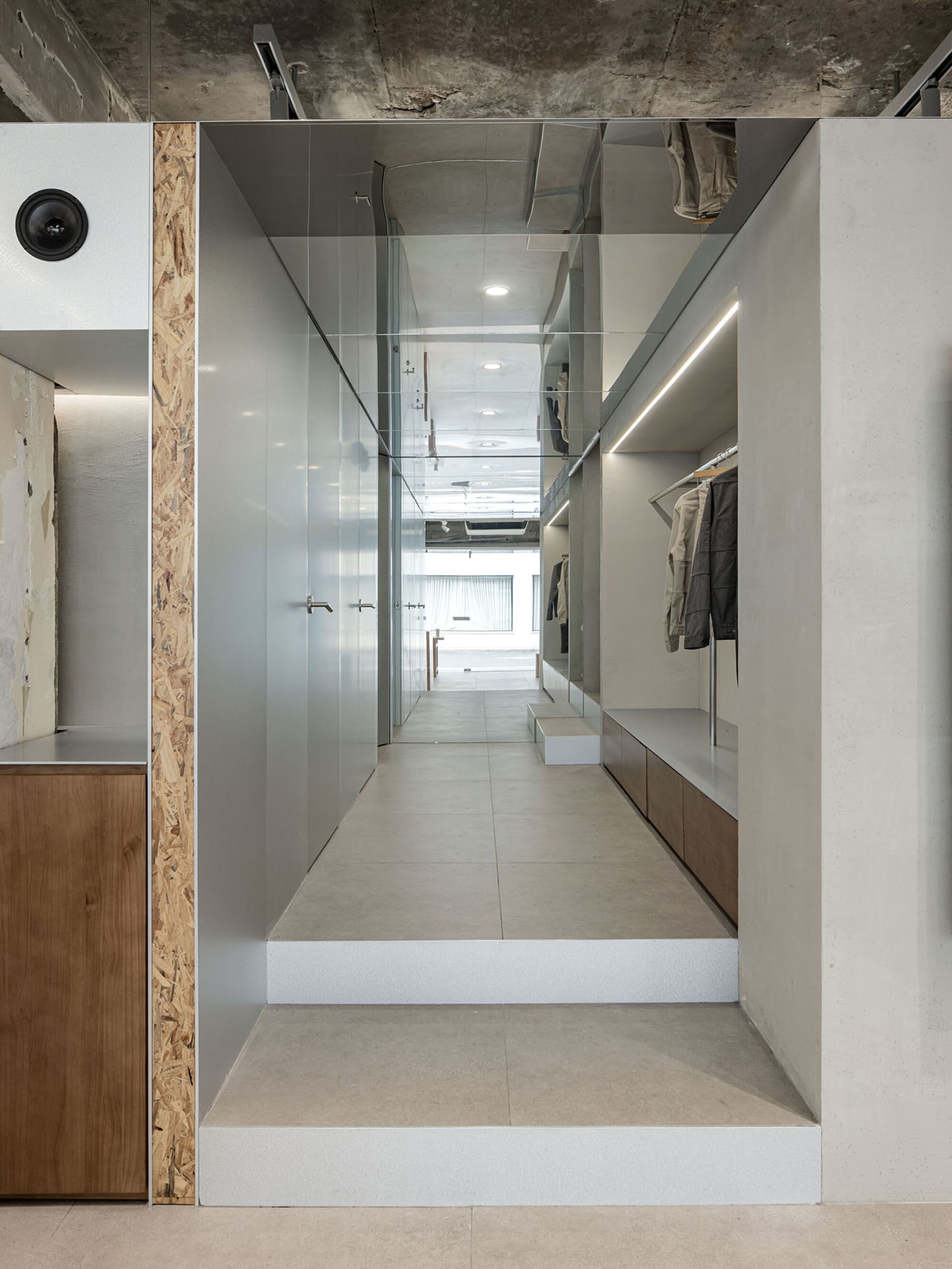 Modern clothing retail space featuring glass storefront and minimalist design.