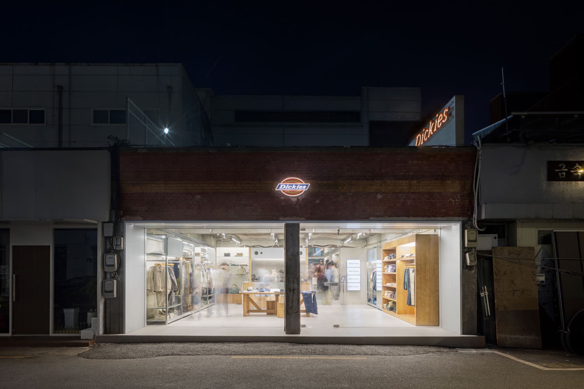 現代零售店面採用玻璃磚與混凝土材質，並以溫暖燈光照亮。