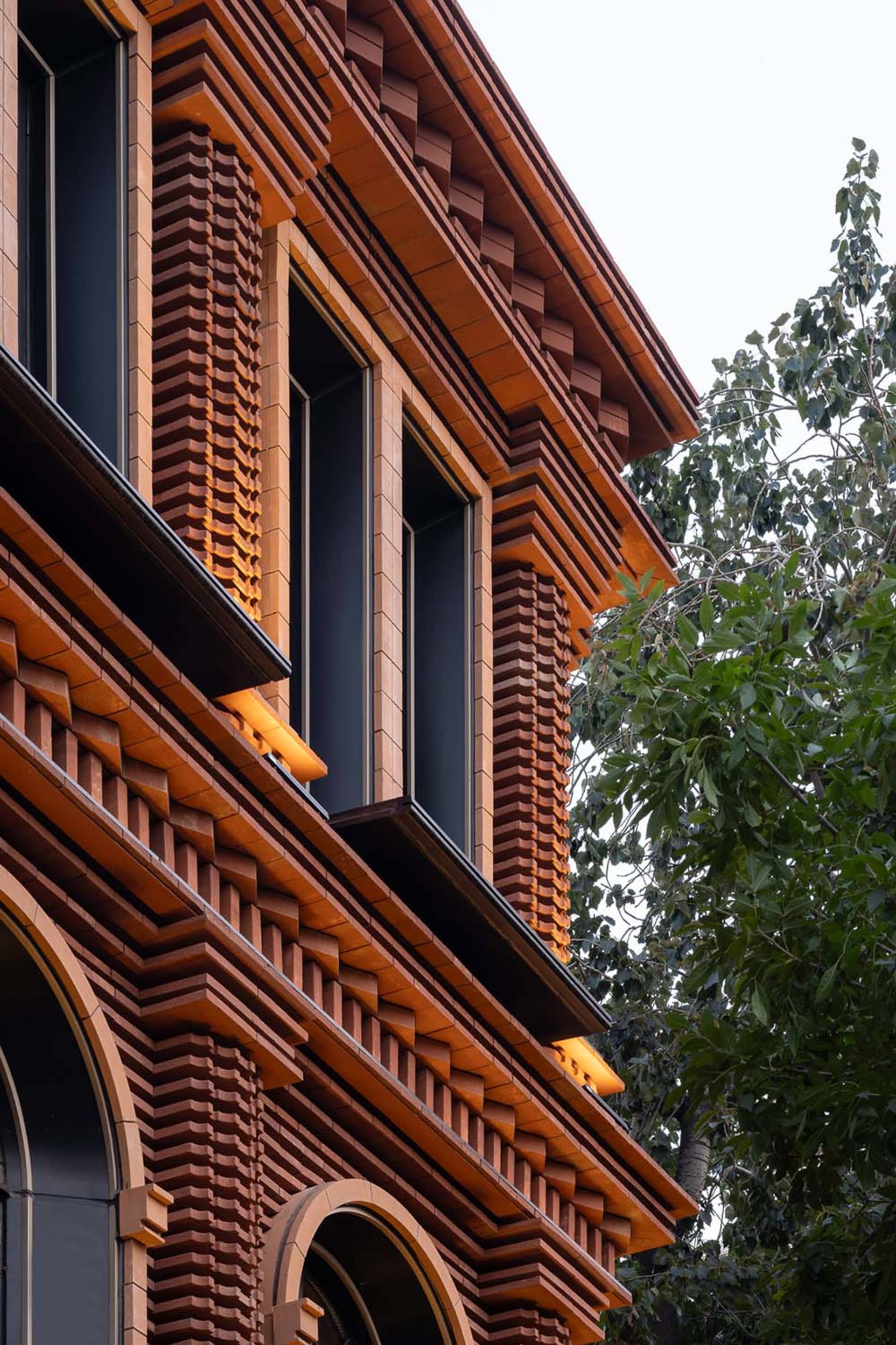 A modern building exterior constructed with brick material, featuring a prominent lighting design.