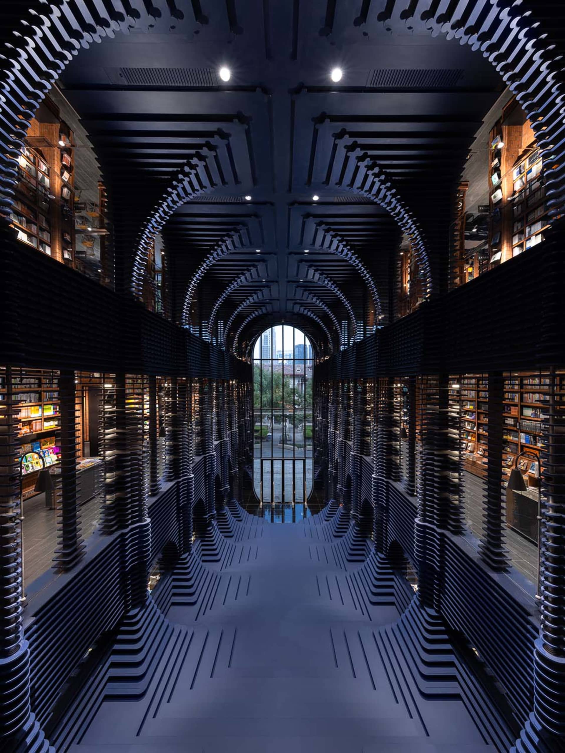 An industrial-style library with metal bookshelves and a mirrored floor.