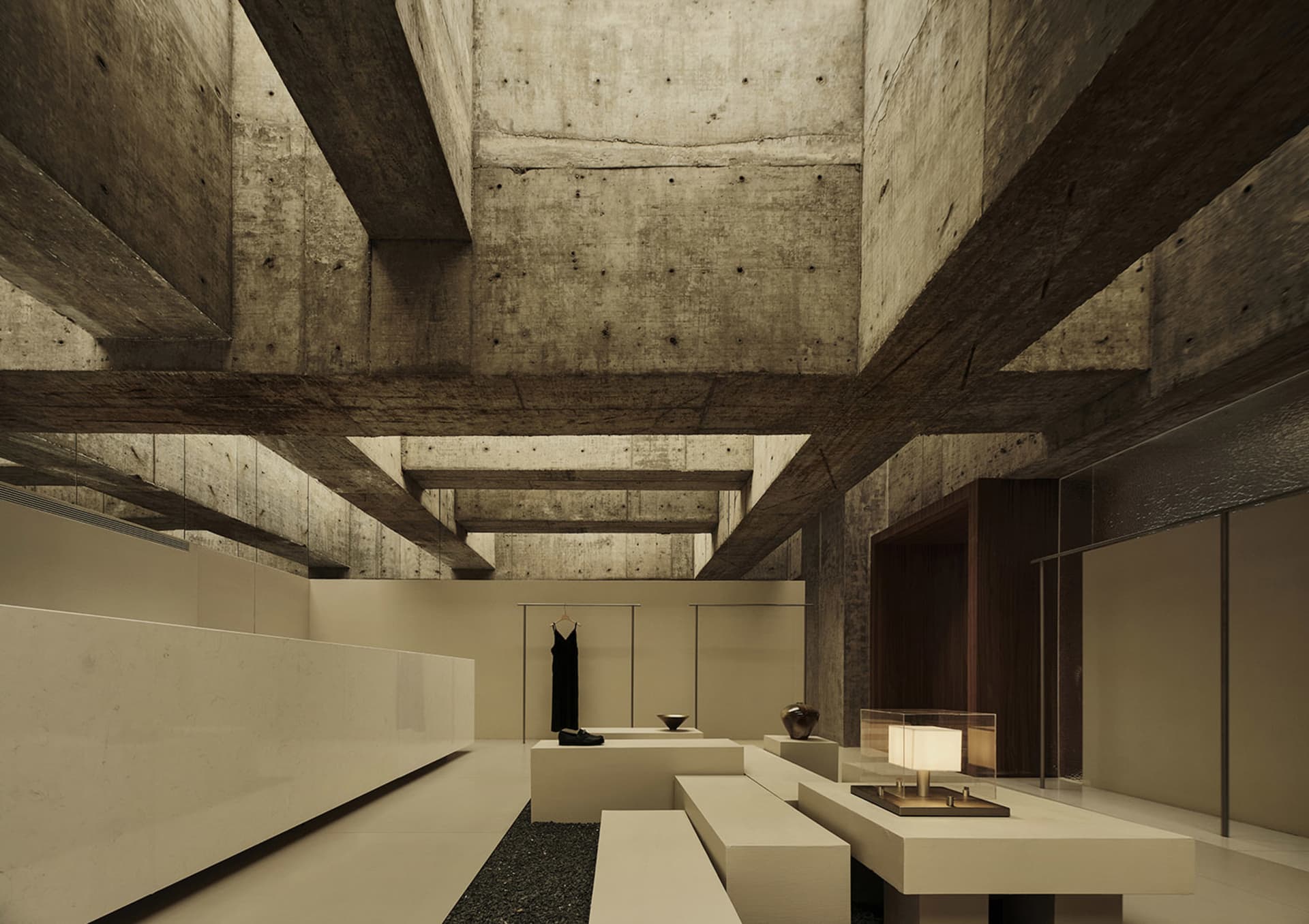 A modern exhibition space with concrete walls and ceiling beams, featuring a minimalist design with white benches and lightin