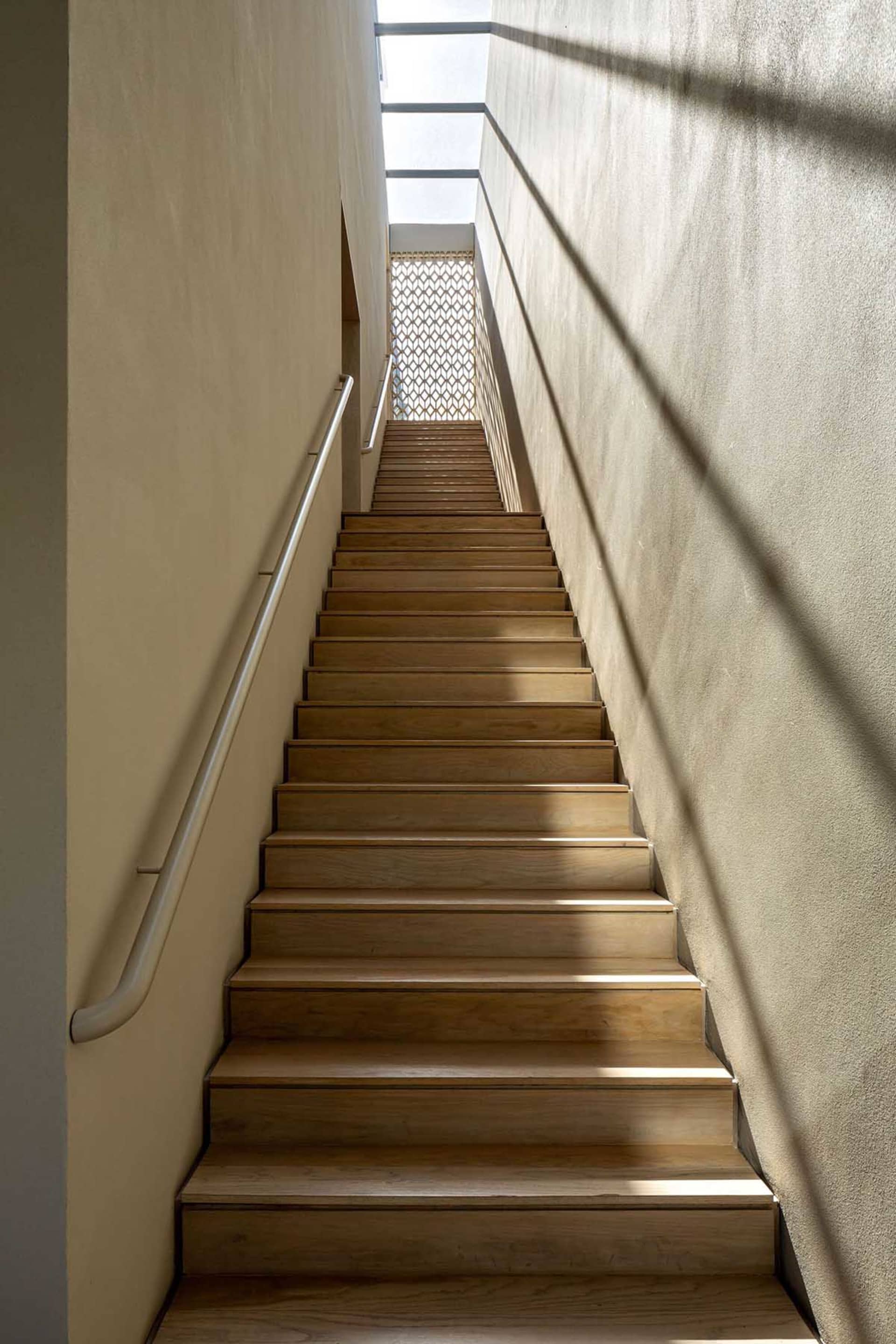 A modern wooden staircase with lighting features.