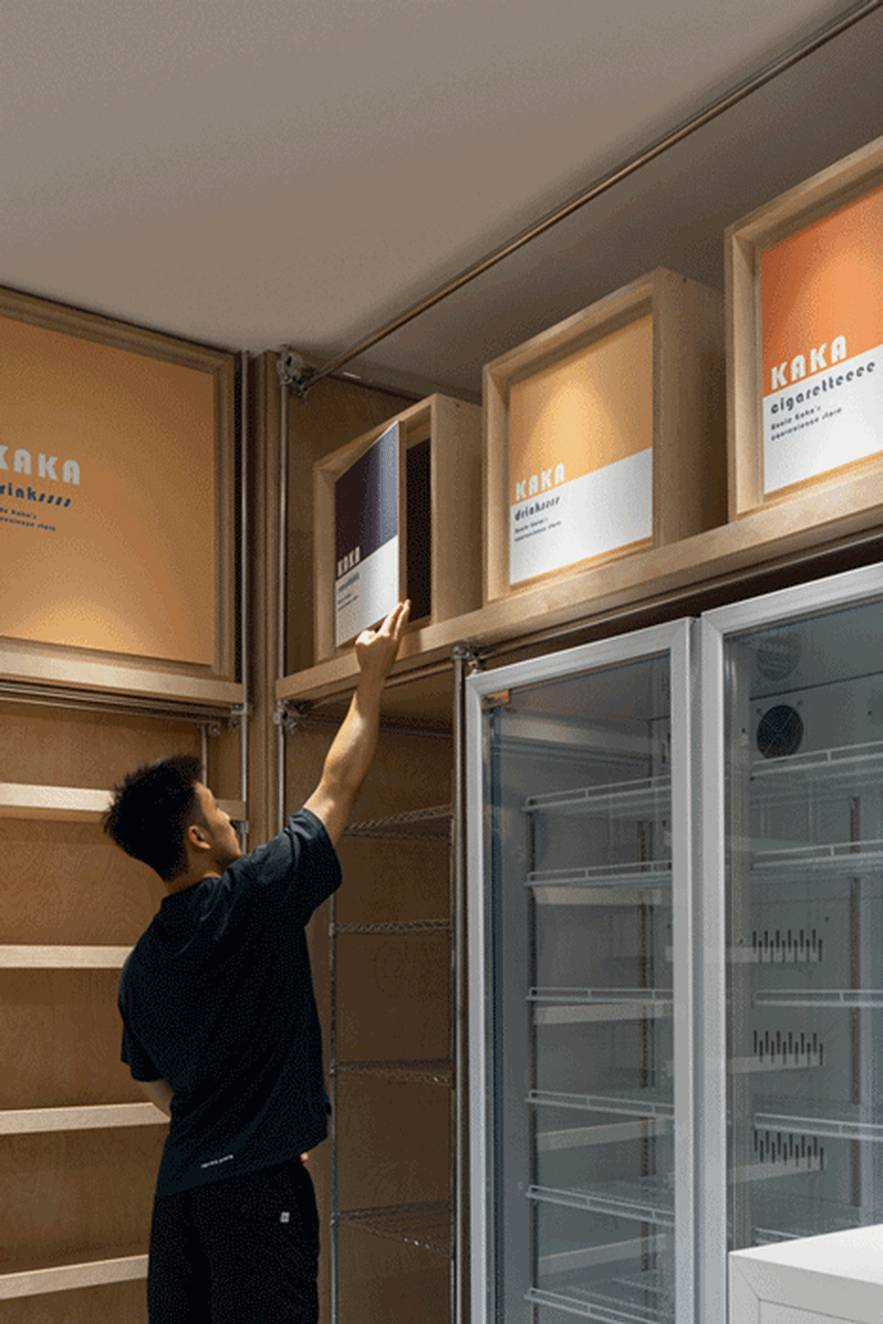 Man arranging shelves in a store interior.