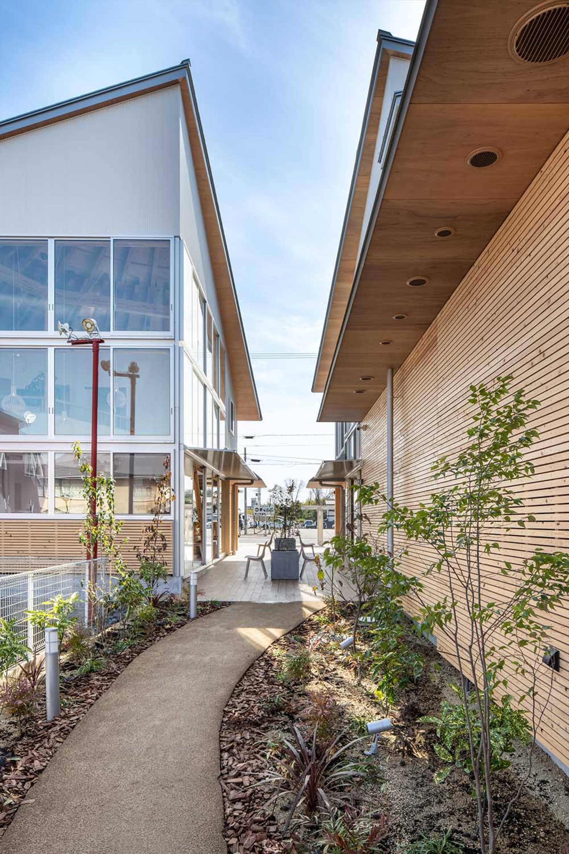 A minimalist commercial building with wooden accents, glass windows, and concrete elements.