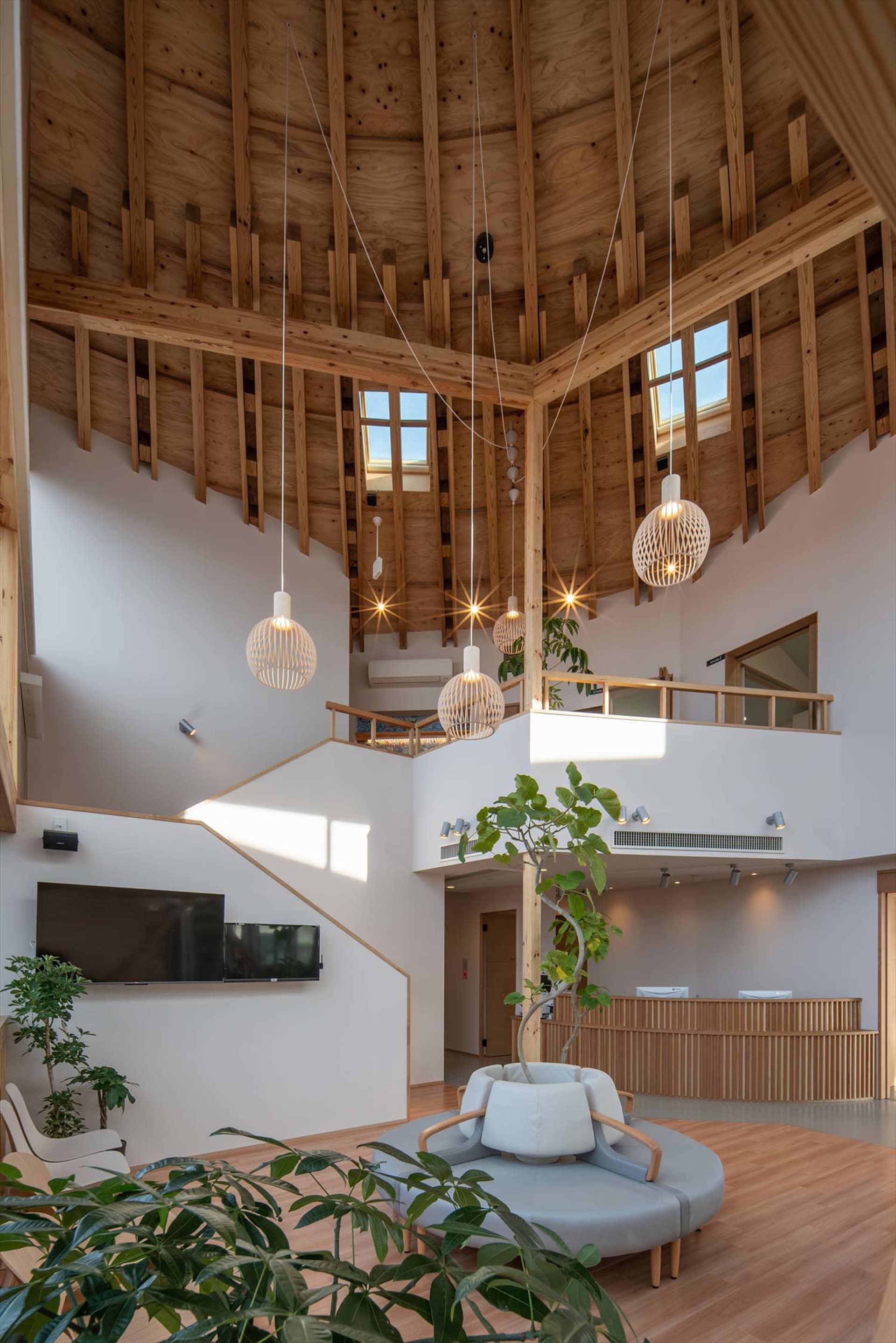 A modern industrial lobby with wooden beams and pendant lights.