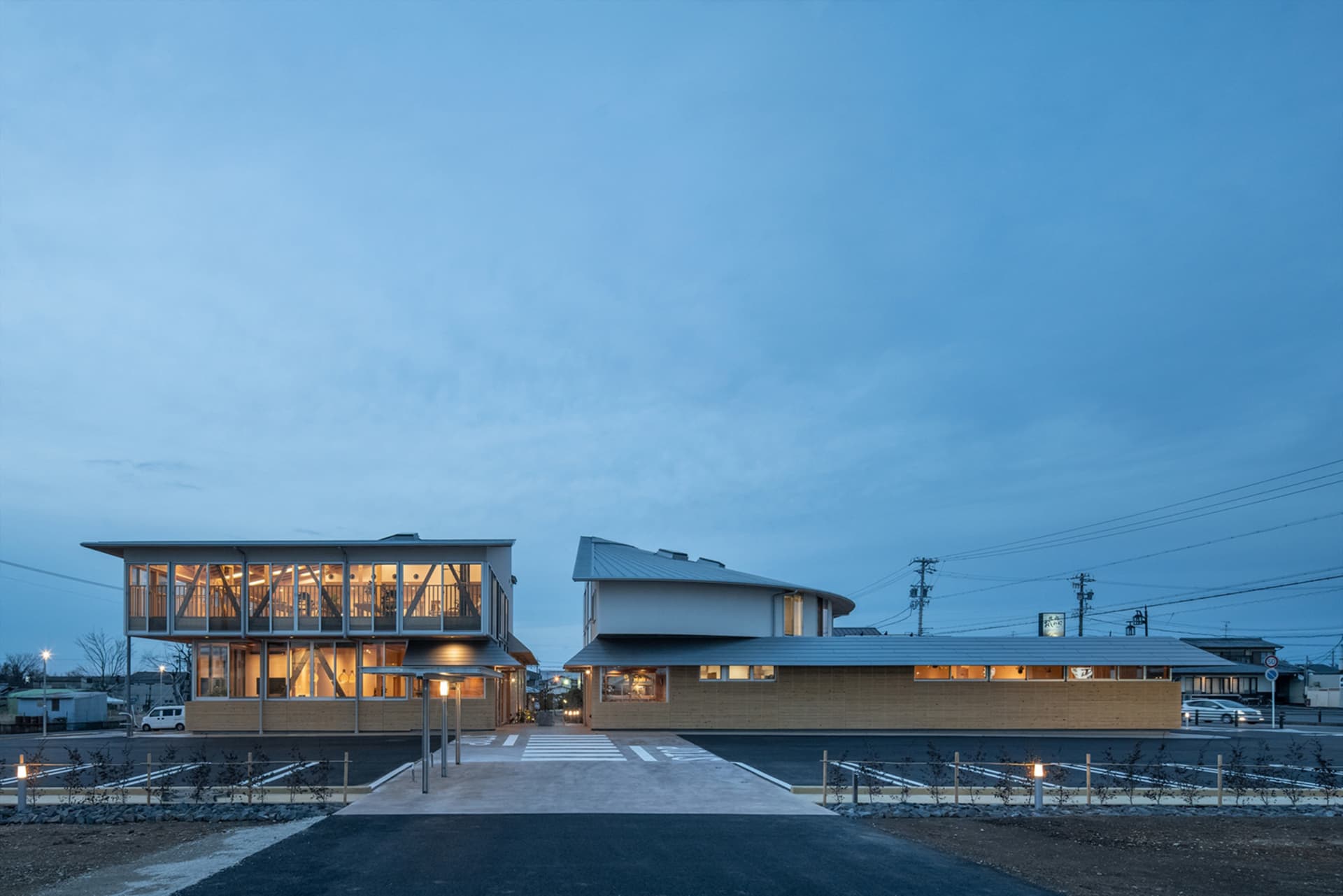 Modern commercial space featuring steel and glass architecture with illuminated interiors.