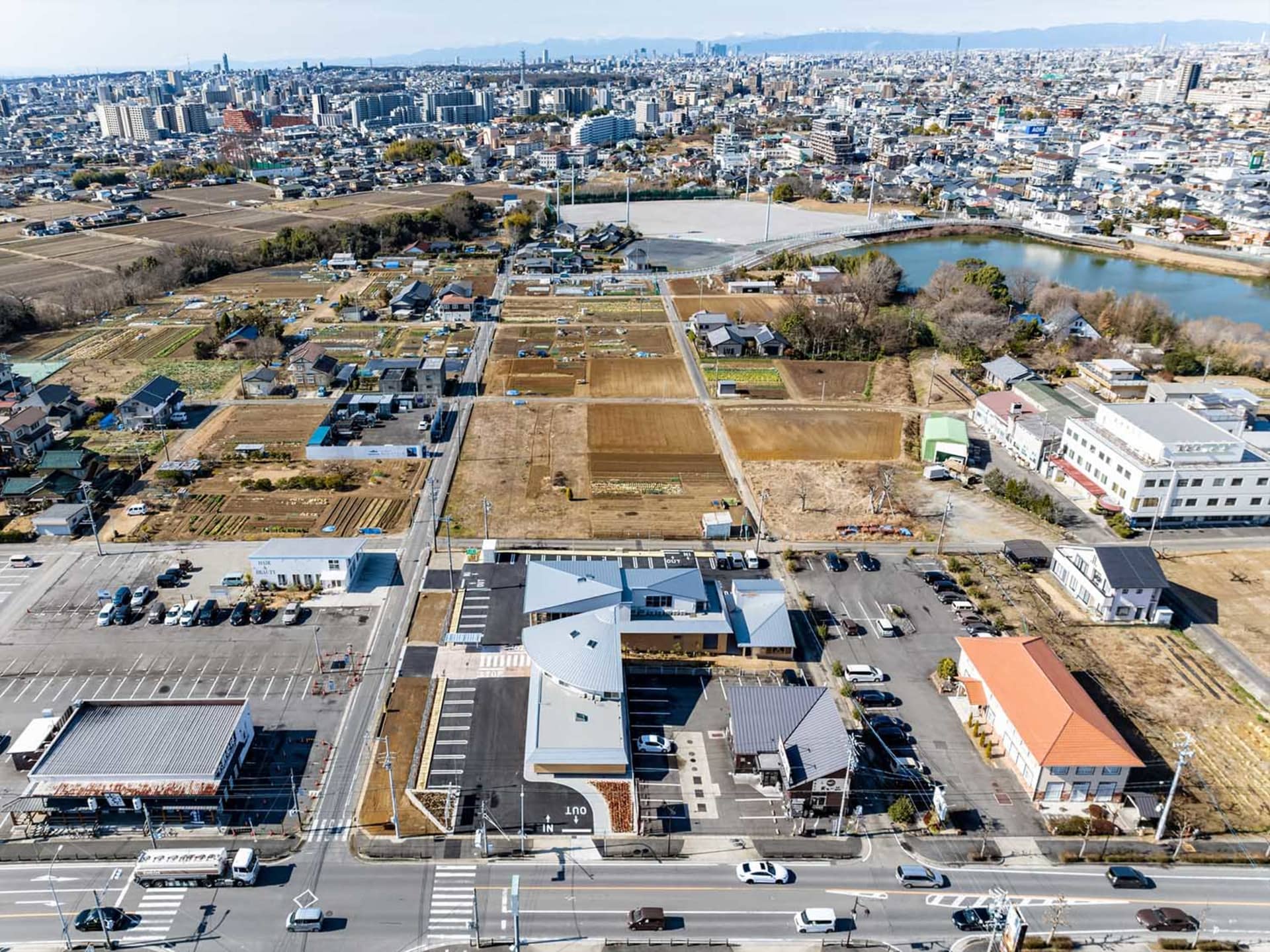 Aerial view of a town square with residential areas, agricultural plots, and urban infrastructure.
