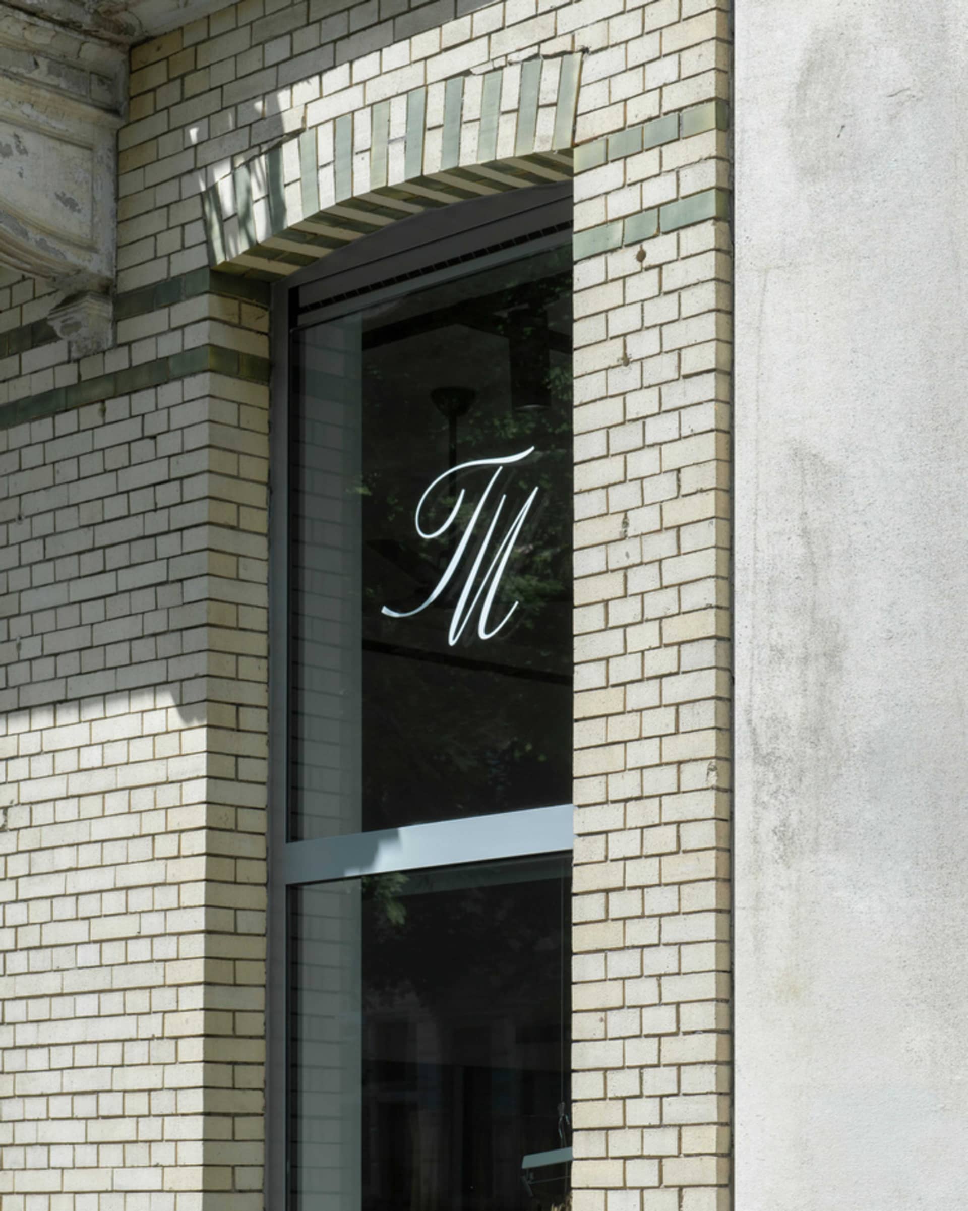 A modern brick facade with the letter 'M' displayed.