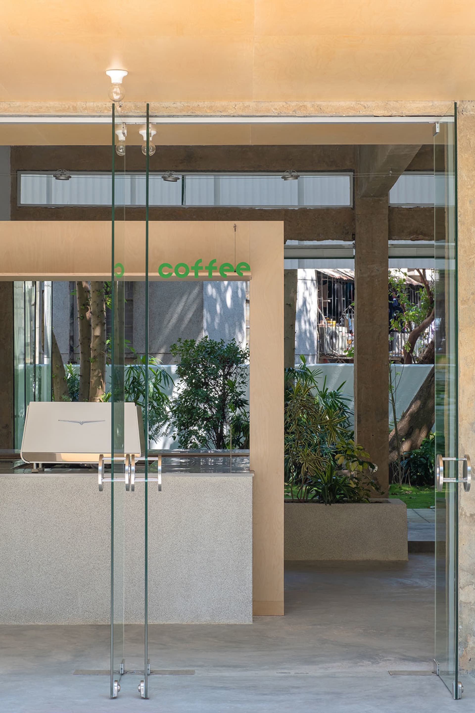 Modern coffee shop interior featuring contemporary concrete and glass materials.