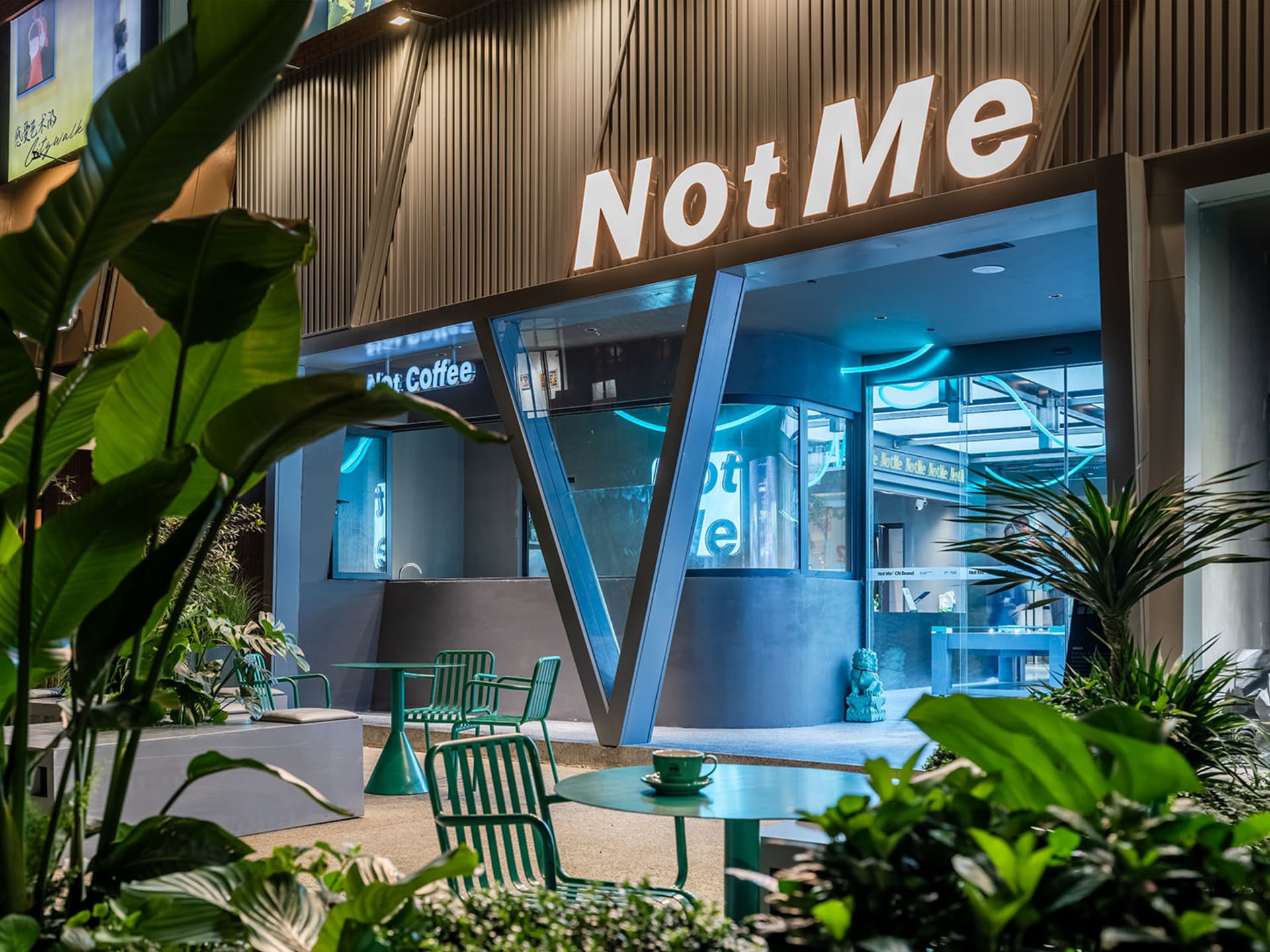 Modern glass storefront of a coffee shop with sleek metal accents and concrete flooring.