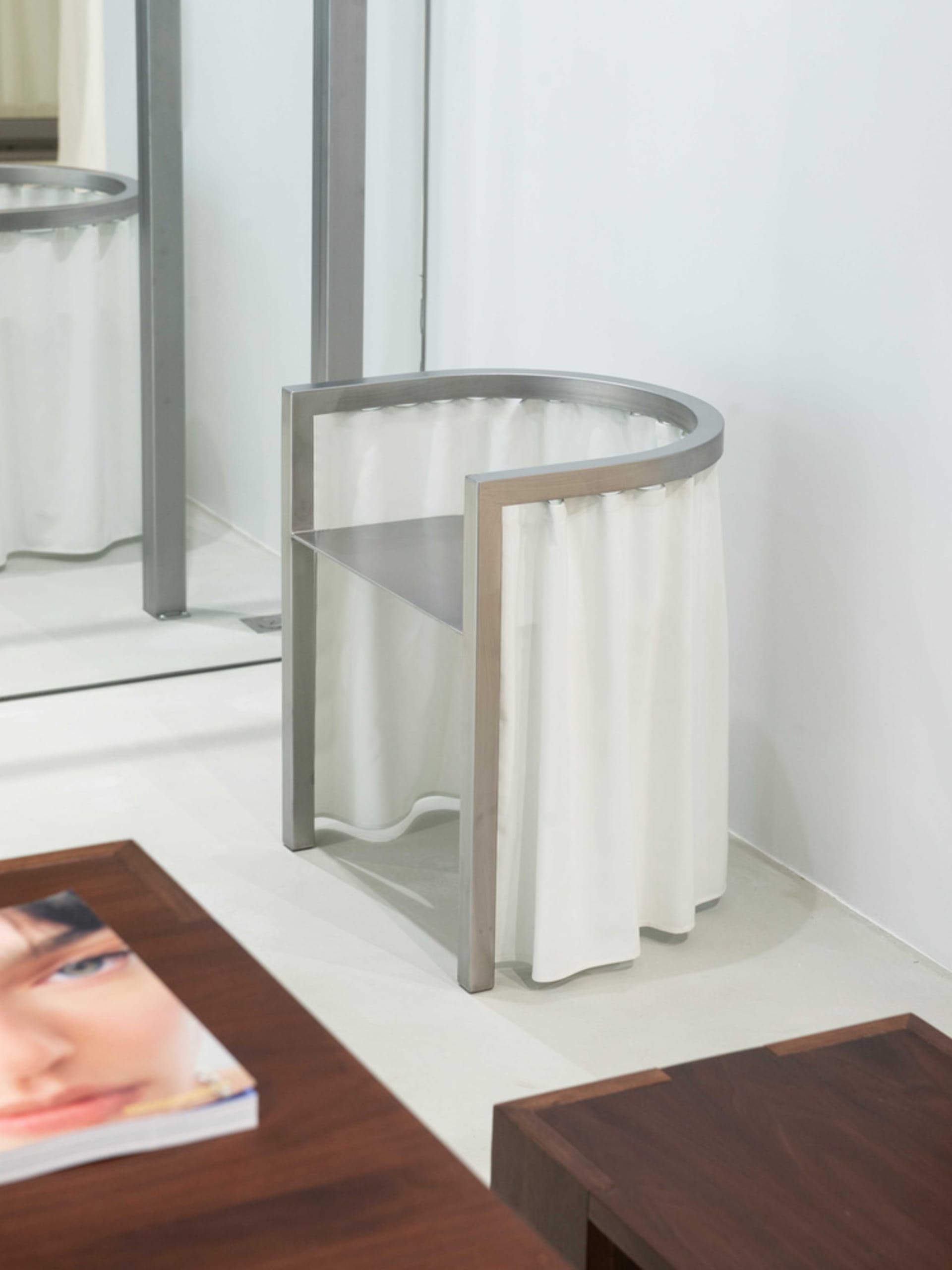 A modern piece of furniture with white curtains.