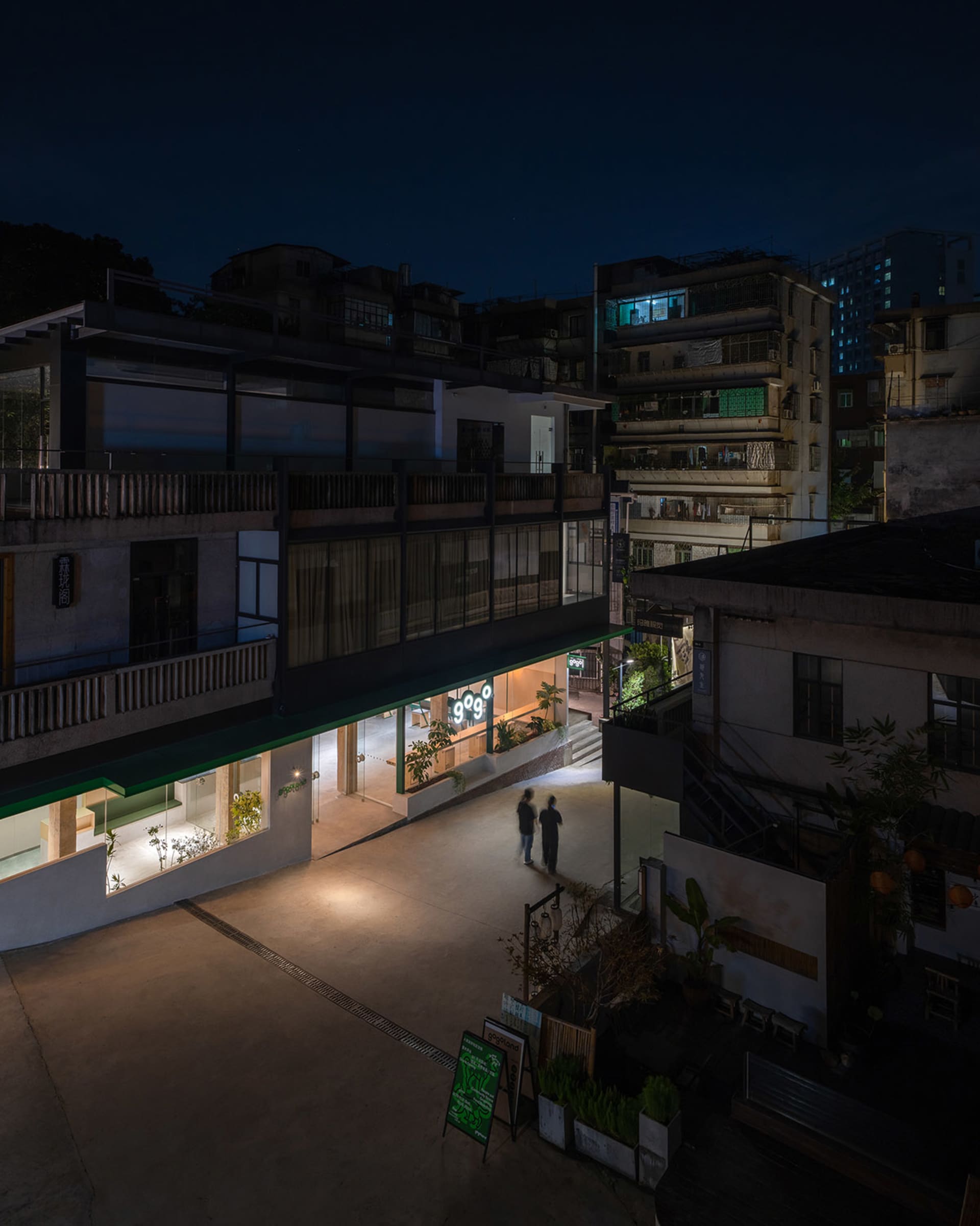 Concrete exterior of a modern restaurant with glass storefront and steel detailing at night.