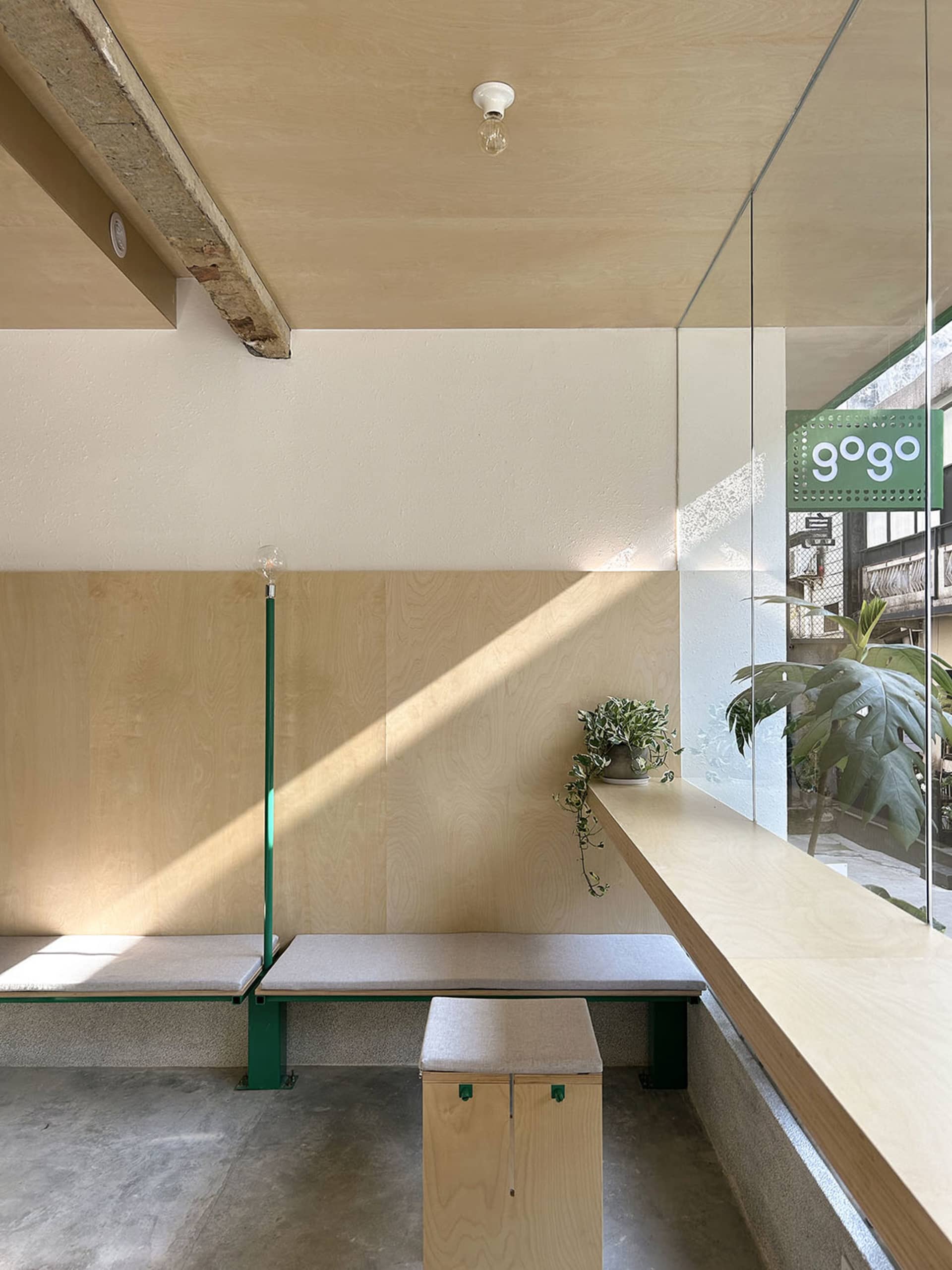 A modern cafe interior with wooden seating and concrete flooring.